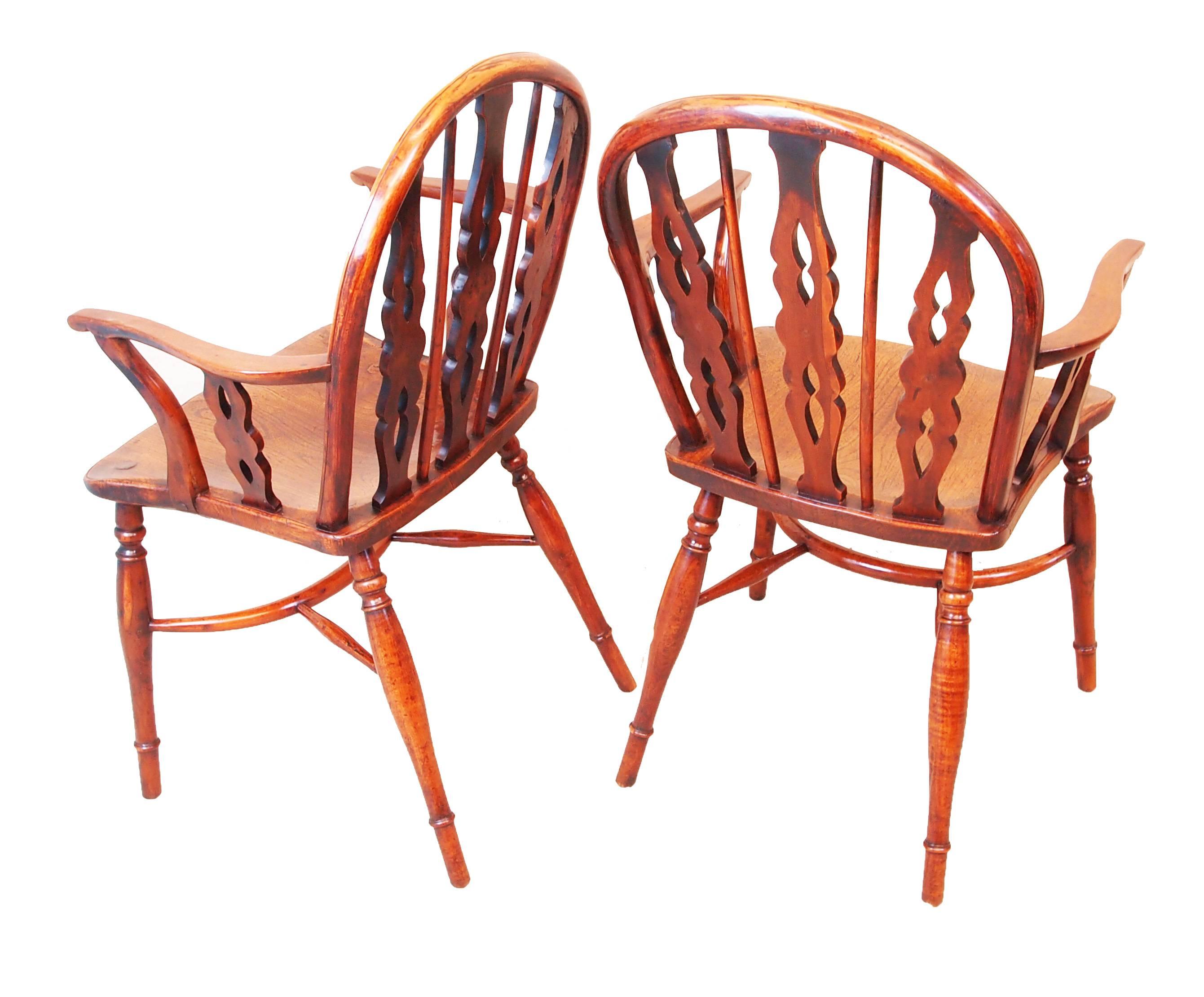 Delightful near matching pair of early 19th century low back.
Yew wood Windsor armchairs having three pierced and shaped 
splats with central set roundels and alternating spindles above 
well figured arms and shaped seats raised on elegant turned