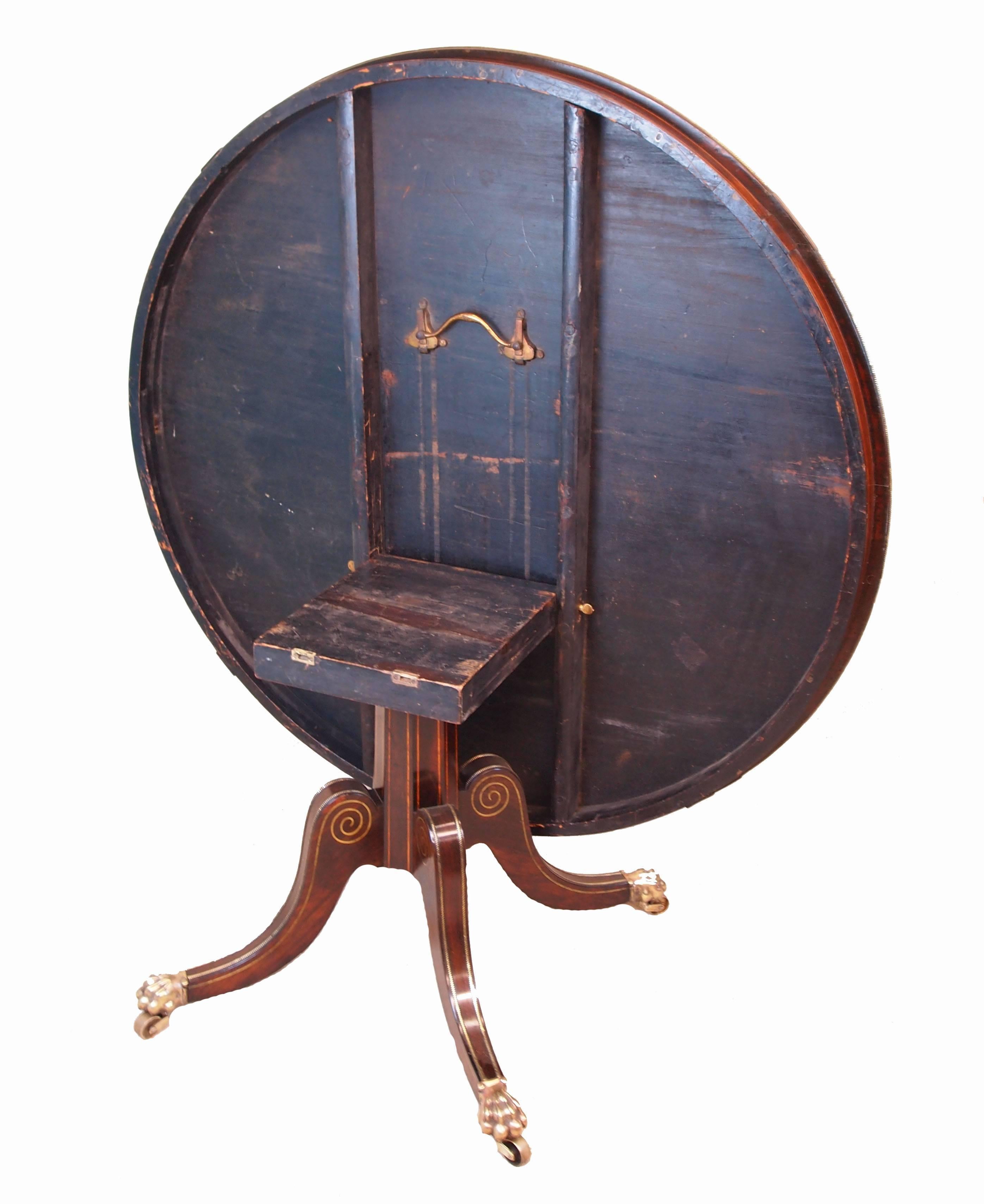 A superb quality Regency Period Indian rosewood breakfast, or centre, table
having superbly figured circular tilting top of good proportions with inlaid 
And brass moulded decoration raised on central support with four elegant
Scrolling sabre