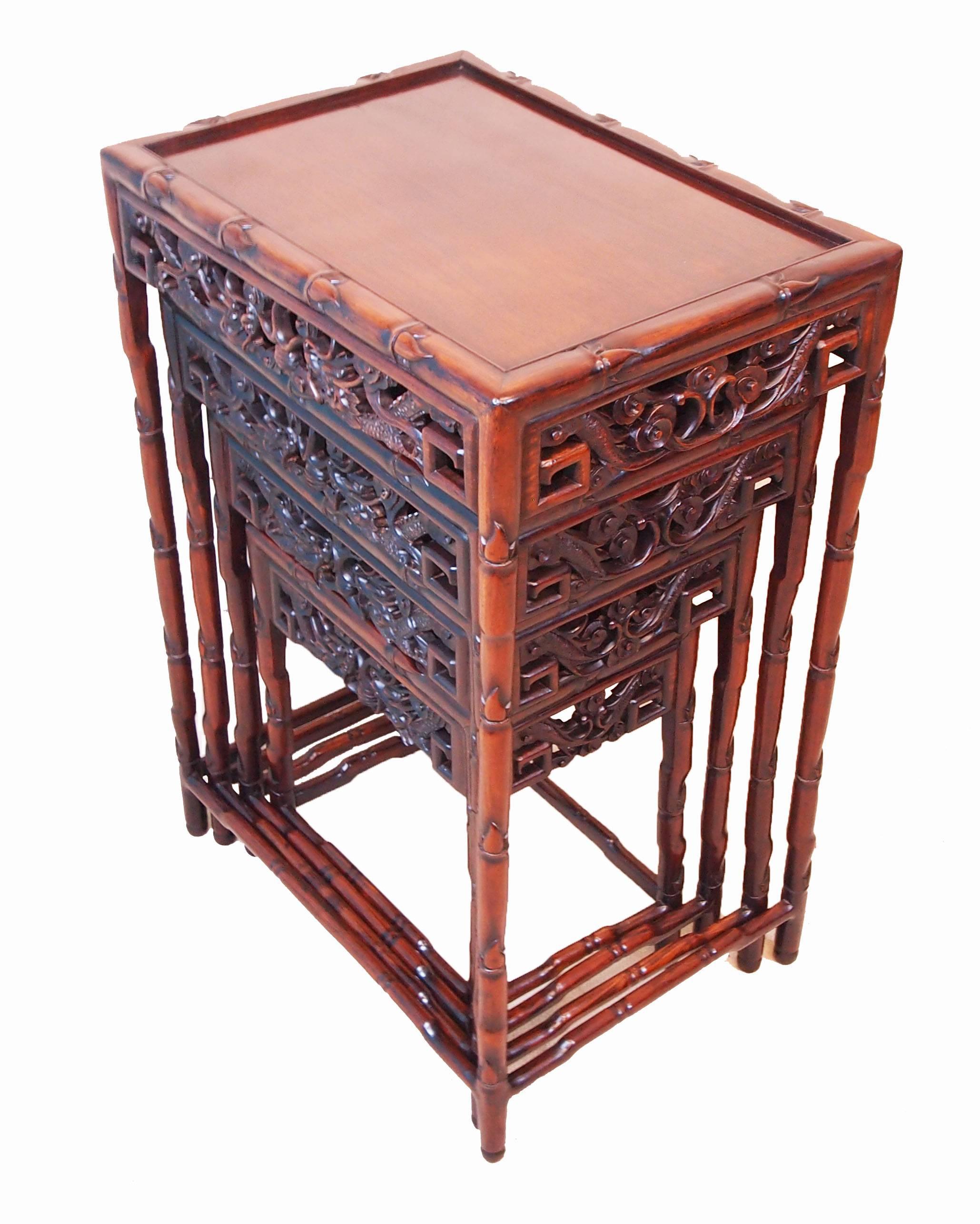 A very attractive mid-19th century oriental hardwood nest of four coffee
tables having well figured panelled tops and carved decoration to pierced
frieze raised on turned legs and stretchers.