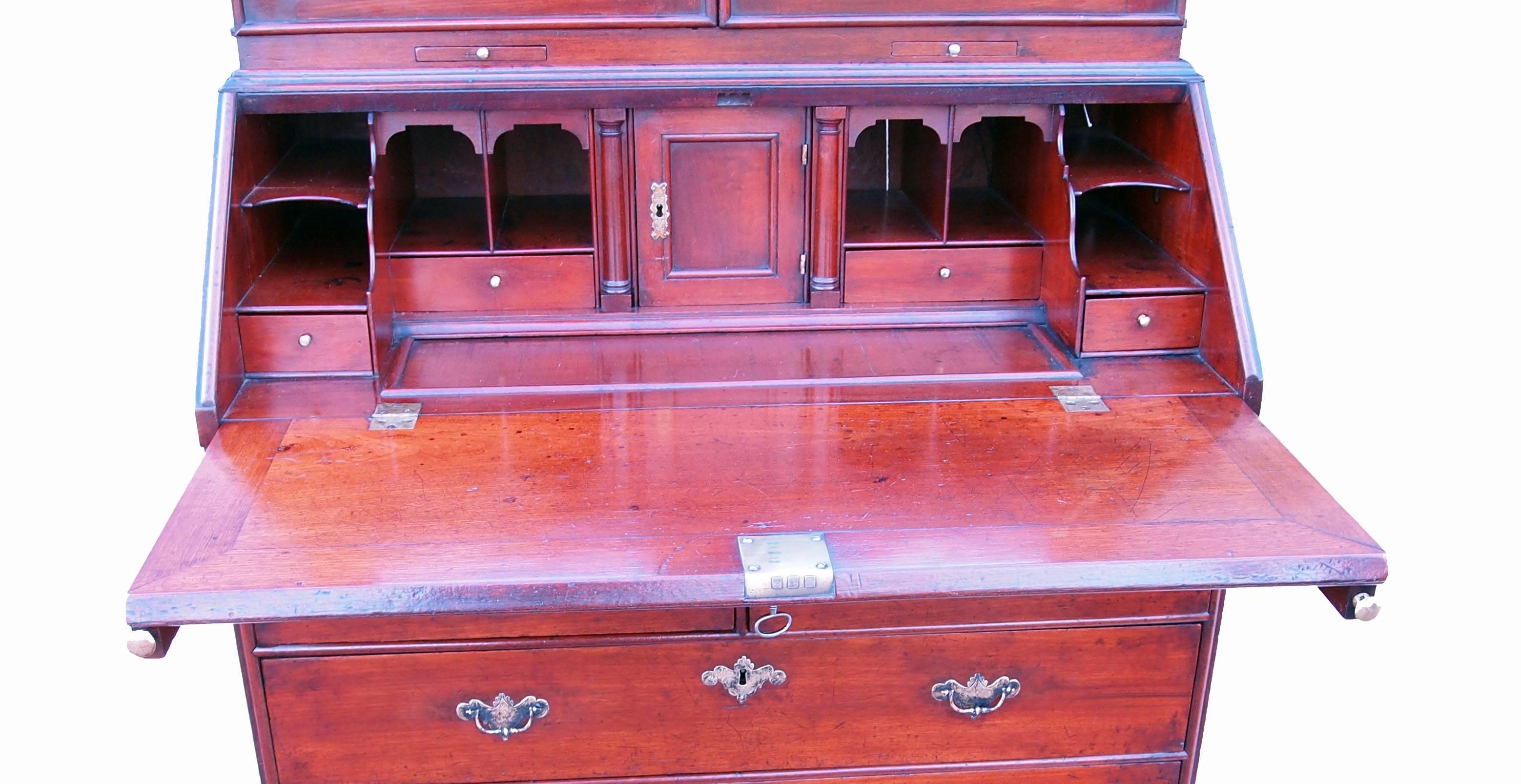 A delightful early 18th century solid walnut bureau bookcase having attractive
double domed top with replacement mirror plates to panelled doors
enclosing well fitted interior above well figured fall, two short and two long
drawers with