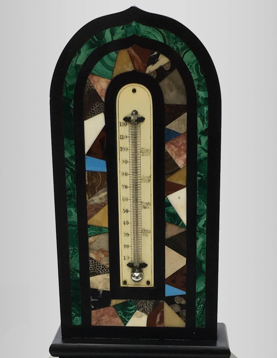 Thermometer in black marble, inlaid with various marbles and bordered in malachite, 19th century.
