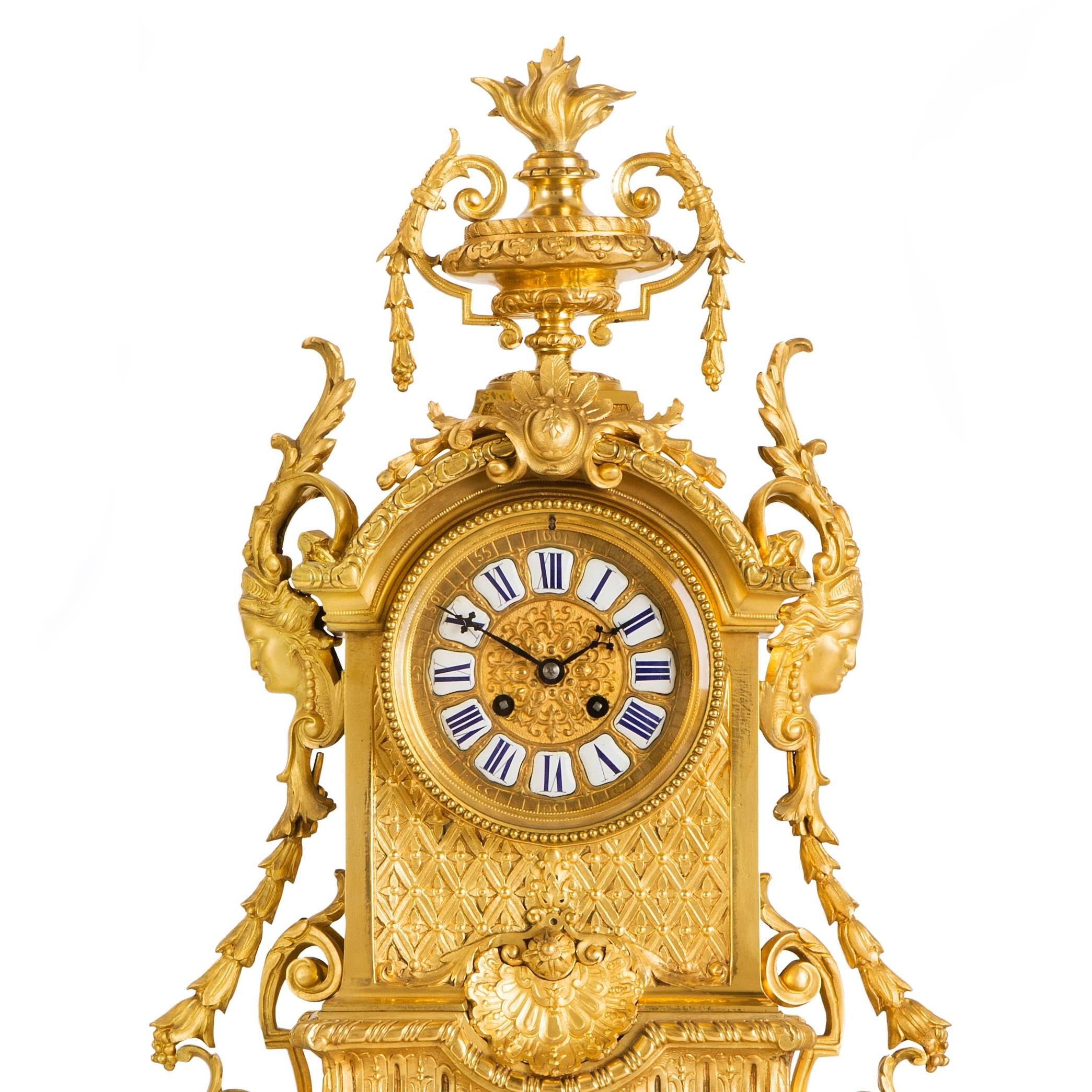 The central clock with dial to the center, displaying hours in individual plaques in Roman numerals and five minute intervals engraved into the ormolu case in Arabic numerals, the case extensively detailed with flowers and foliage, and featuring two