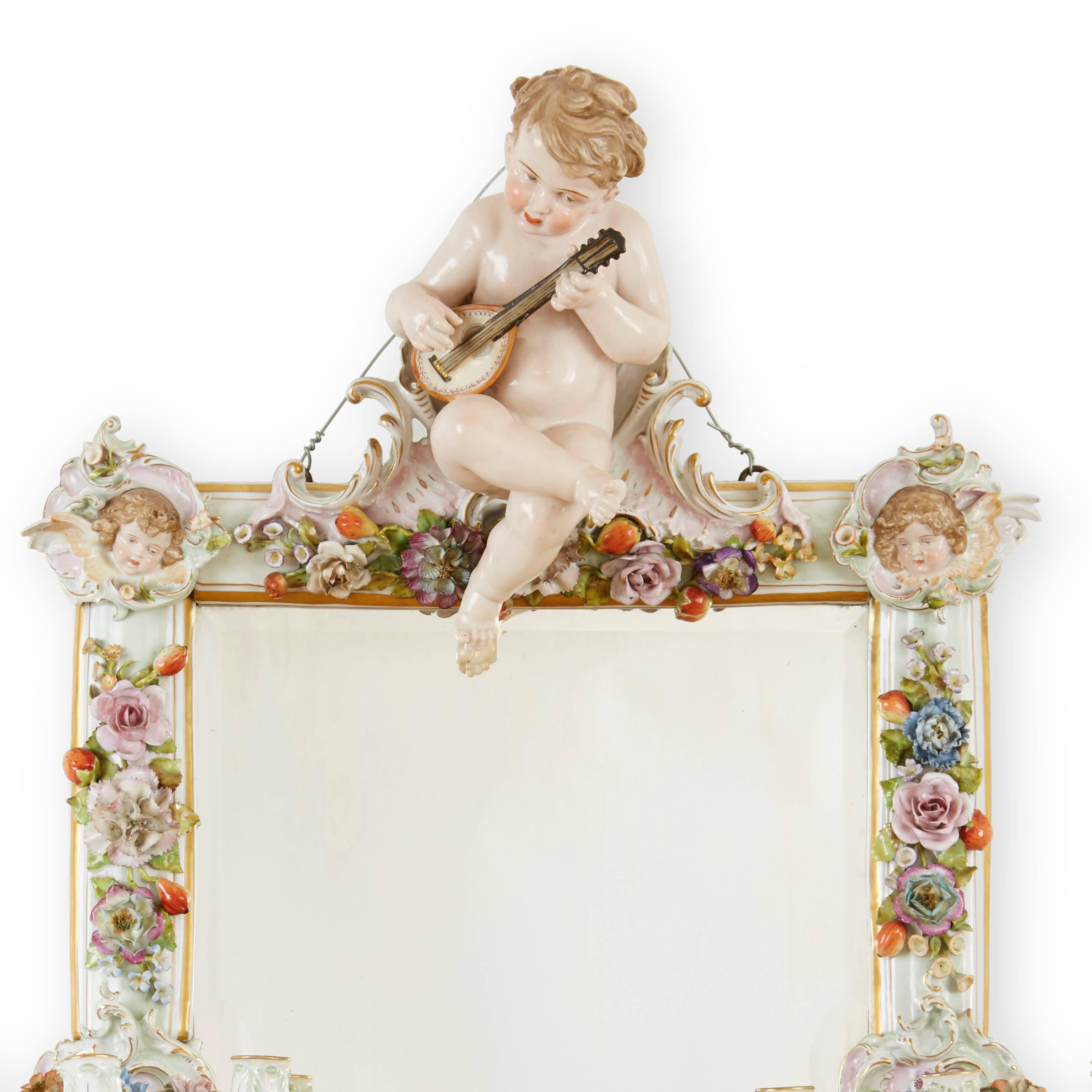 The rectangular plate surmounted by a cherub playing a mandolin above a frame with angel heads, flower heads and foliage. 

This elegant antique mirror is an excellent example of high quality Meissen porcelain work; even every flower petal is