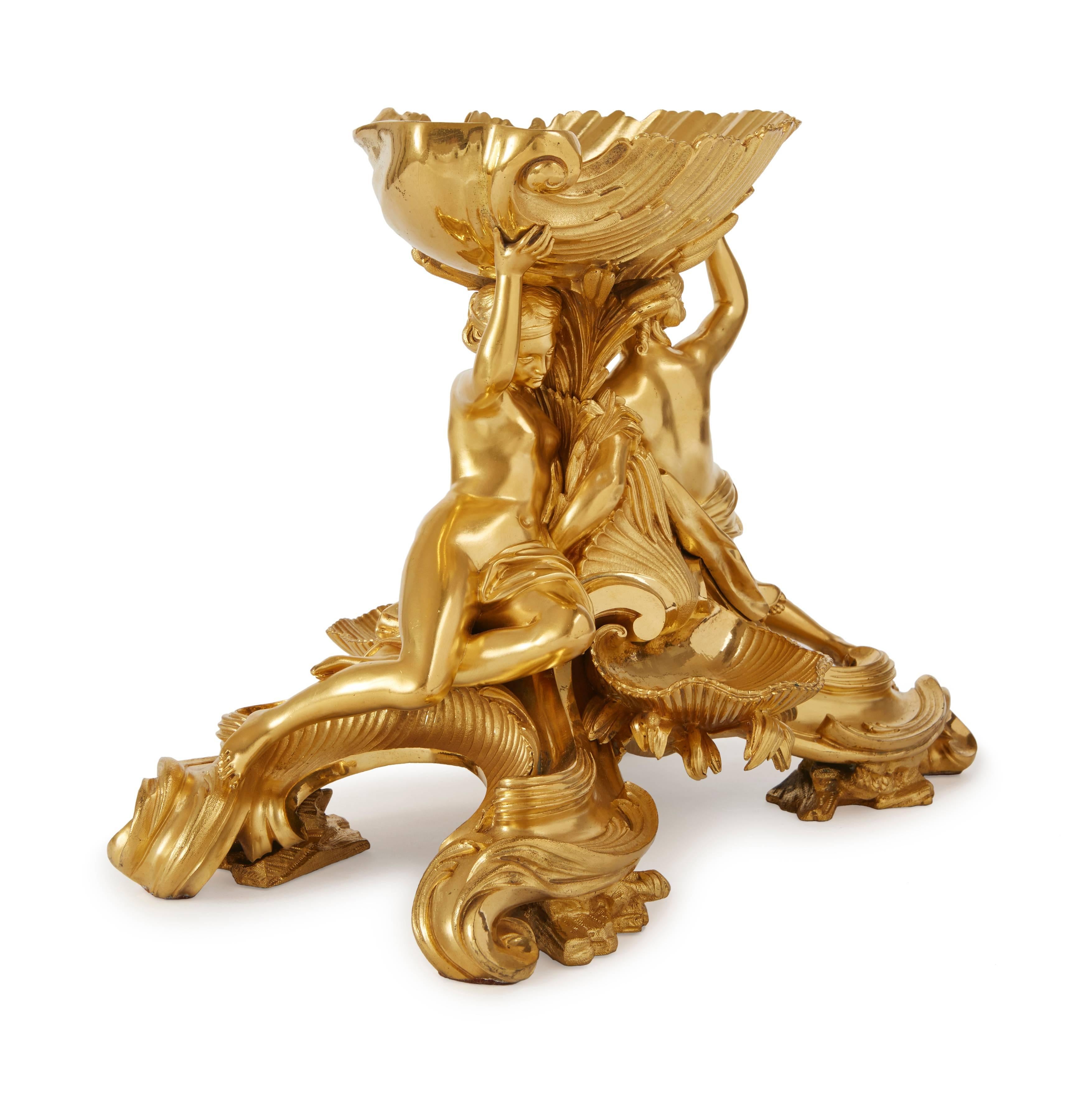 Very fine ormolu salt-cellar centrepiece. Modelled as two nymphs lying on a Rocaille base with foliage and shells, supporting a large shell above their heads.