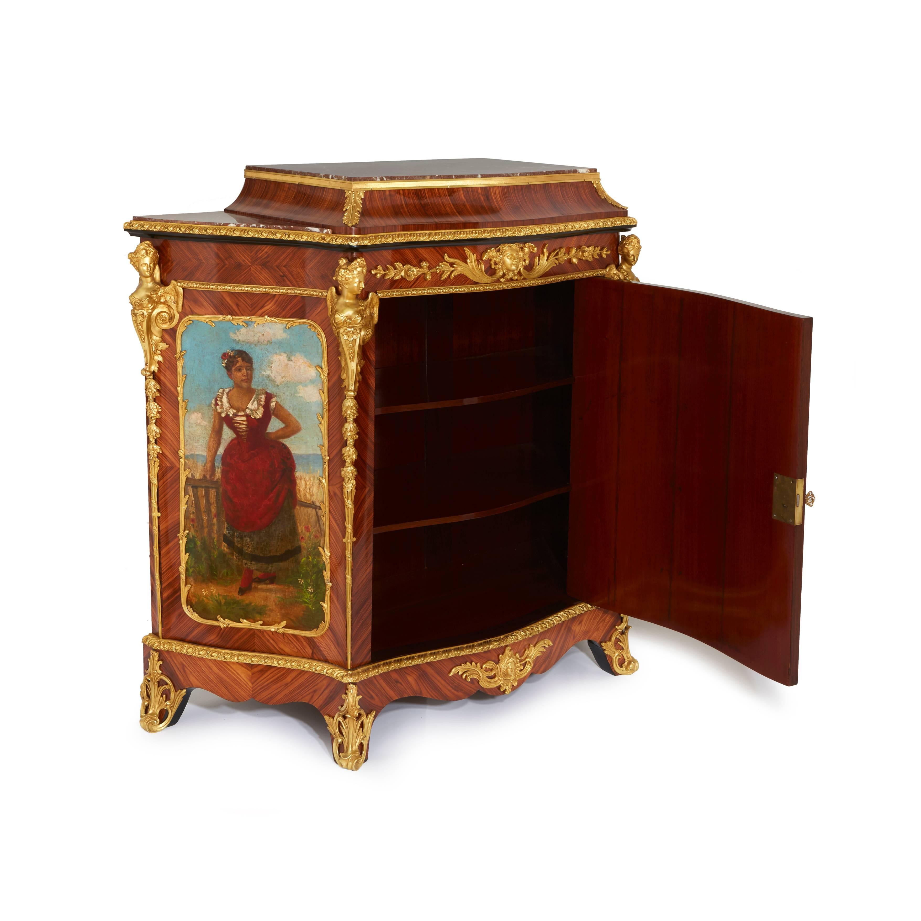The ormolu mounted painted and tulipwood side cabinets decorated in the Louis XV style, each cabinet with marble tops on a raised platform decorated with floral garlands, above a central ormolu frieze centered by a female bust and floral decor to