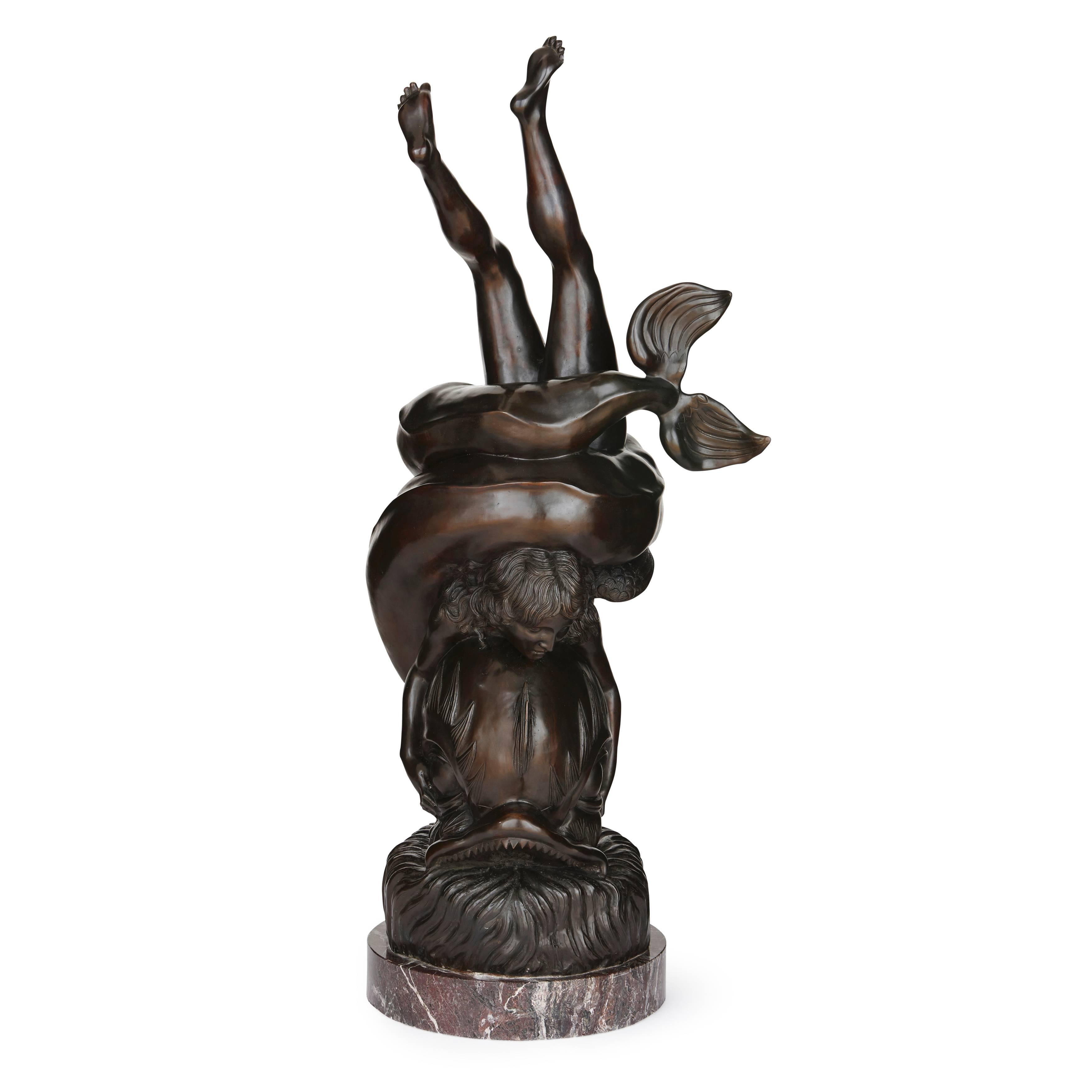 The bronze figurative group on a cylindrical marble base with the mythological god Amor encircled by a large dolphin, signed 'Poirier'.

This bronze model is based on the design of an original ancient Roman marble fountain, which was discovered in