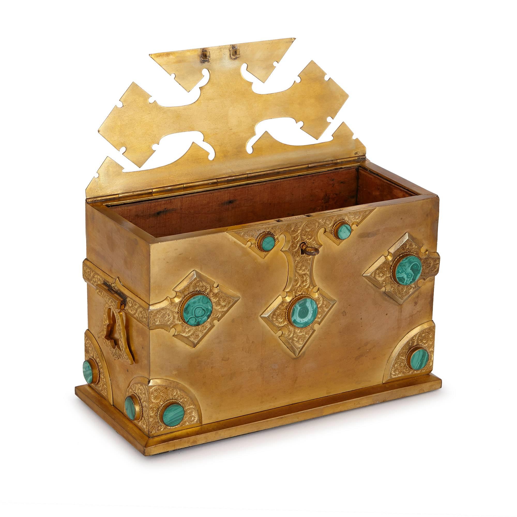 Of rectangular form, featuring an unusual cut-away lid and decorated with Gothic style detailing set with circular malachite discs, inscribed 'Tiffany & Co, Union Square'.

With green malachite detailing beautifully offset by golden ormolu, this