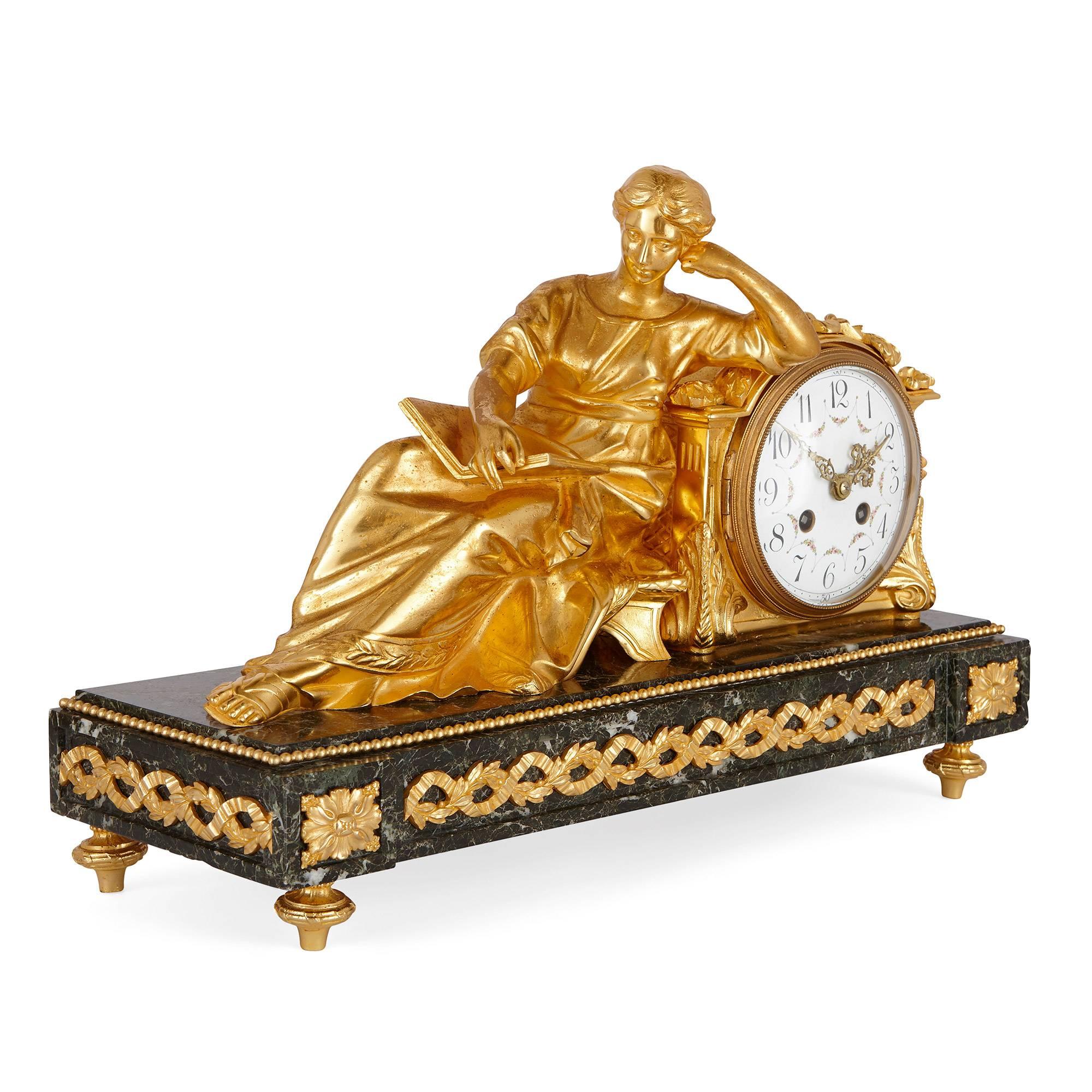 The gilt metal clock on green veined marble base depicting a seated lady holding a book, with a pair of matching urns of similar style.

8-day striking movement, stamped with an oval cartouche depicting an 'A' beneath a crown.

This fine antique
