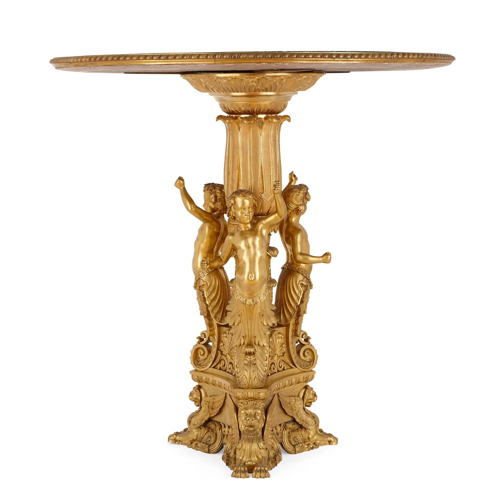The ormolu base decorated with three half length figures ending in lion head feet, ormolu-mounted circular malachite top.

The fine gold gilt of this Russian table is offset beautifully by its striking green malachite top, making the work a
