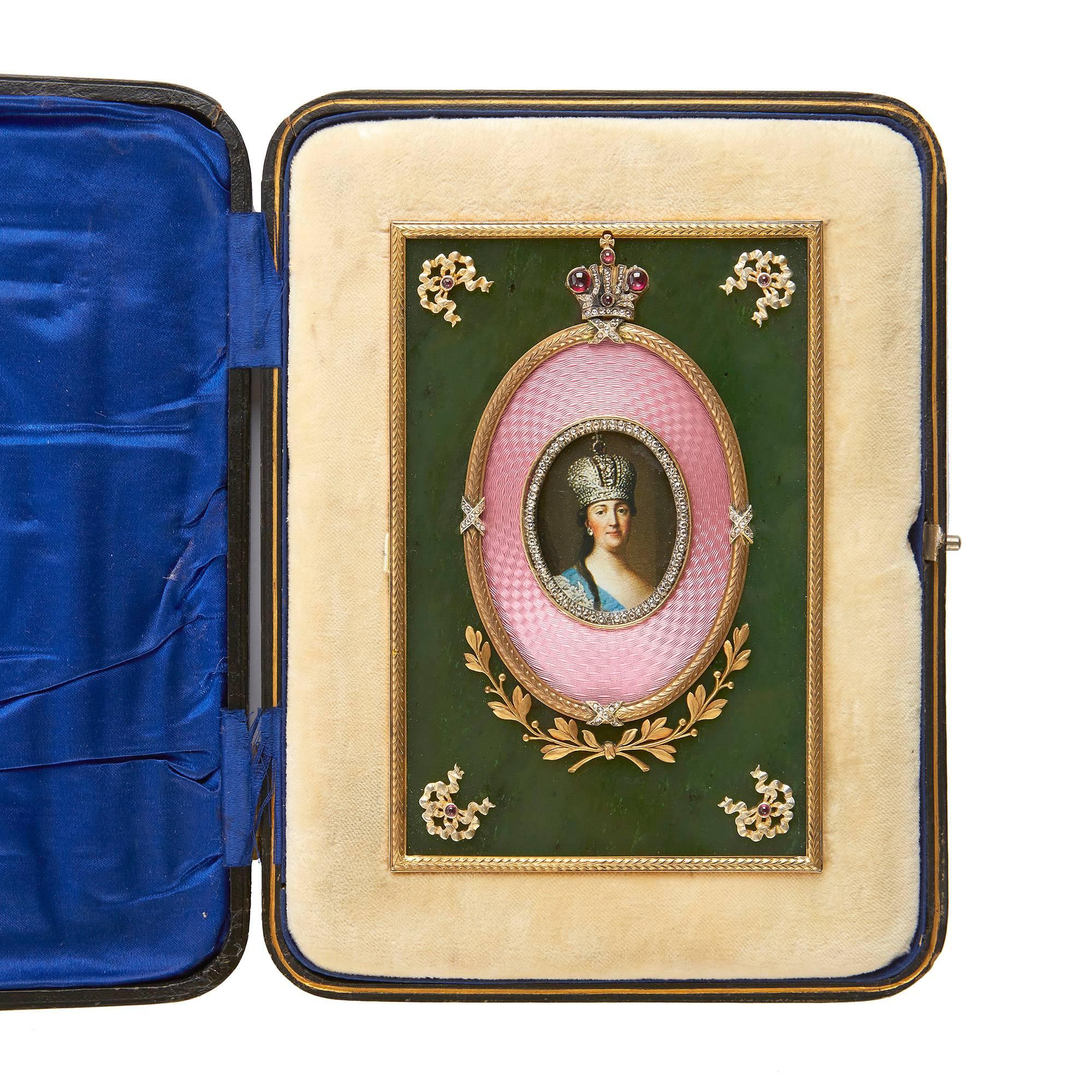 The central oval shaped photograph surrounded by a band of diamonds and pink guilloché enamel with a silver gilt border surmounted by a crown containing further precious stones and with floral decoration below, set on a nephrite panel with
