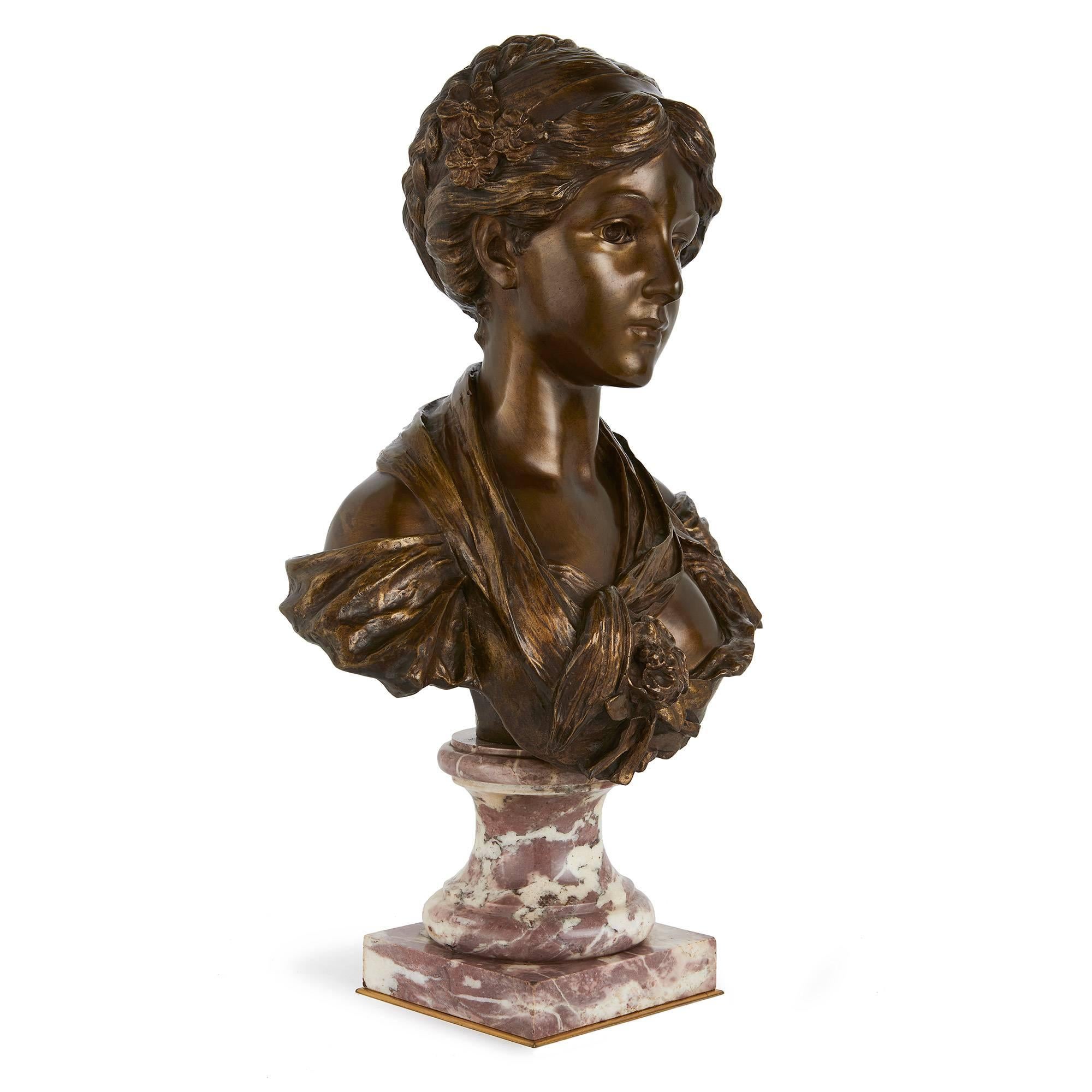 On a veined marble base; after Jean-Baptiste Greuze, inscribed on the reverse 'D'Apres Greuze (Musee Du Louvre)'.

This beautiful patinated bronze bust depicts an elegant young lady, who gazes out at the viewer with a serene look that creates an