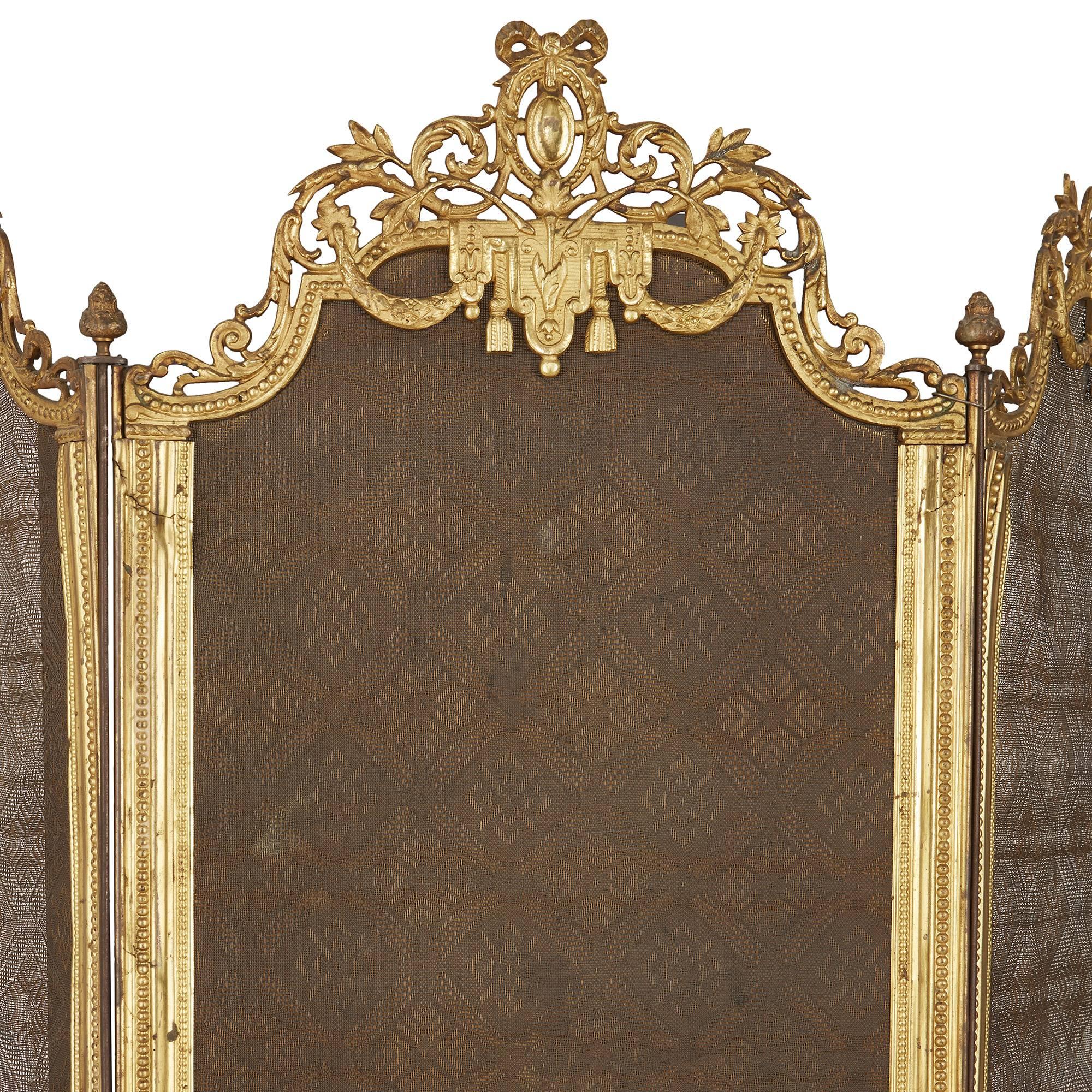 The four panels of rectangular shape, with ormolu frame surmounted by ornate Baroque style detailing, the two end panels with handles on the top.

This elegant antique folding fire screen features beautifully detailed gilt bronze mounts, that