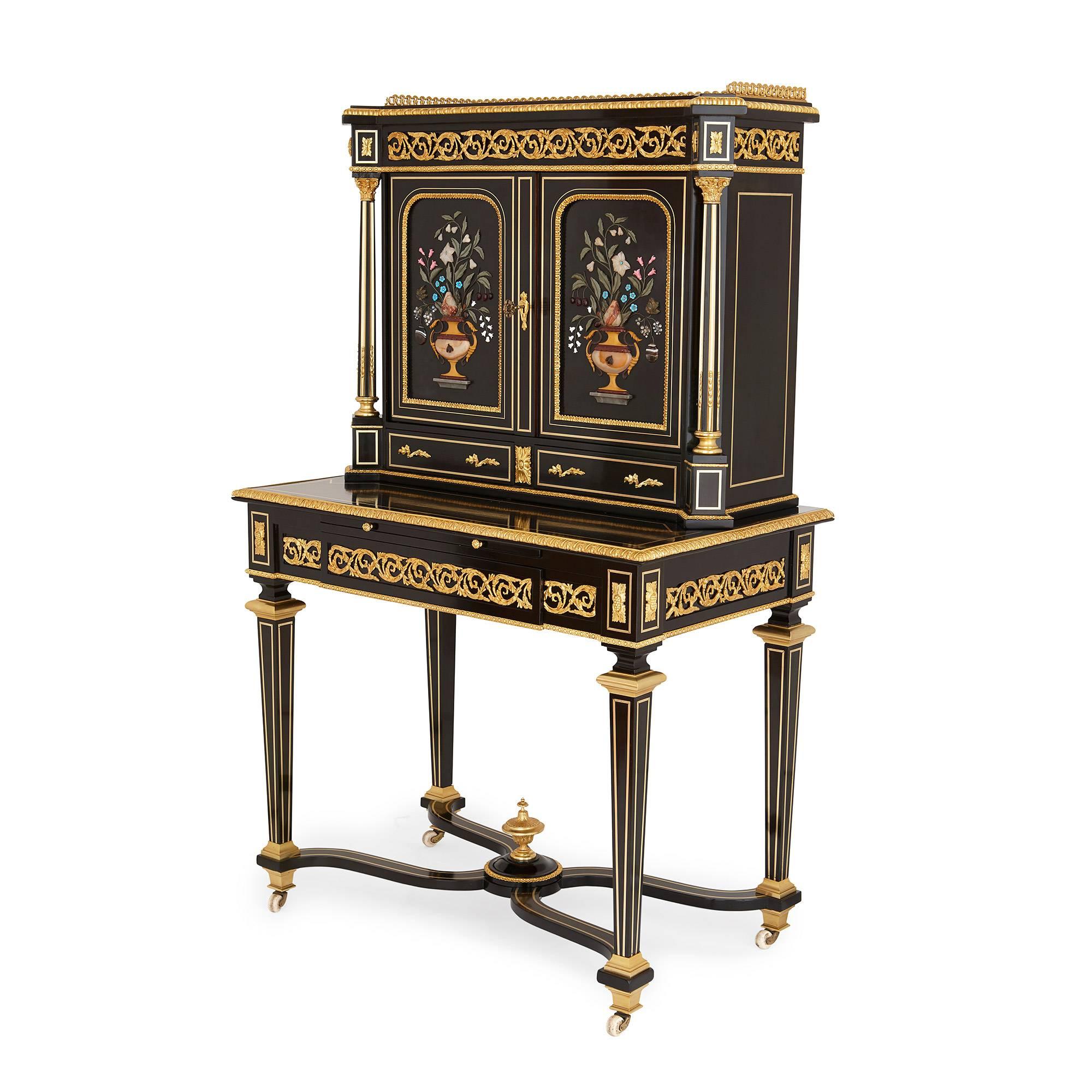 The upper section of the bonheur du jour with doors mounted with hardstone vases of fruit and flowers, opening to an interior shelf, above two small drawers, the base with a gilt-tooled leather lined writing slide above a long frieze drawer, leading