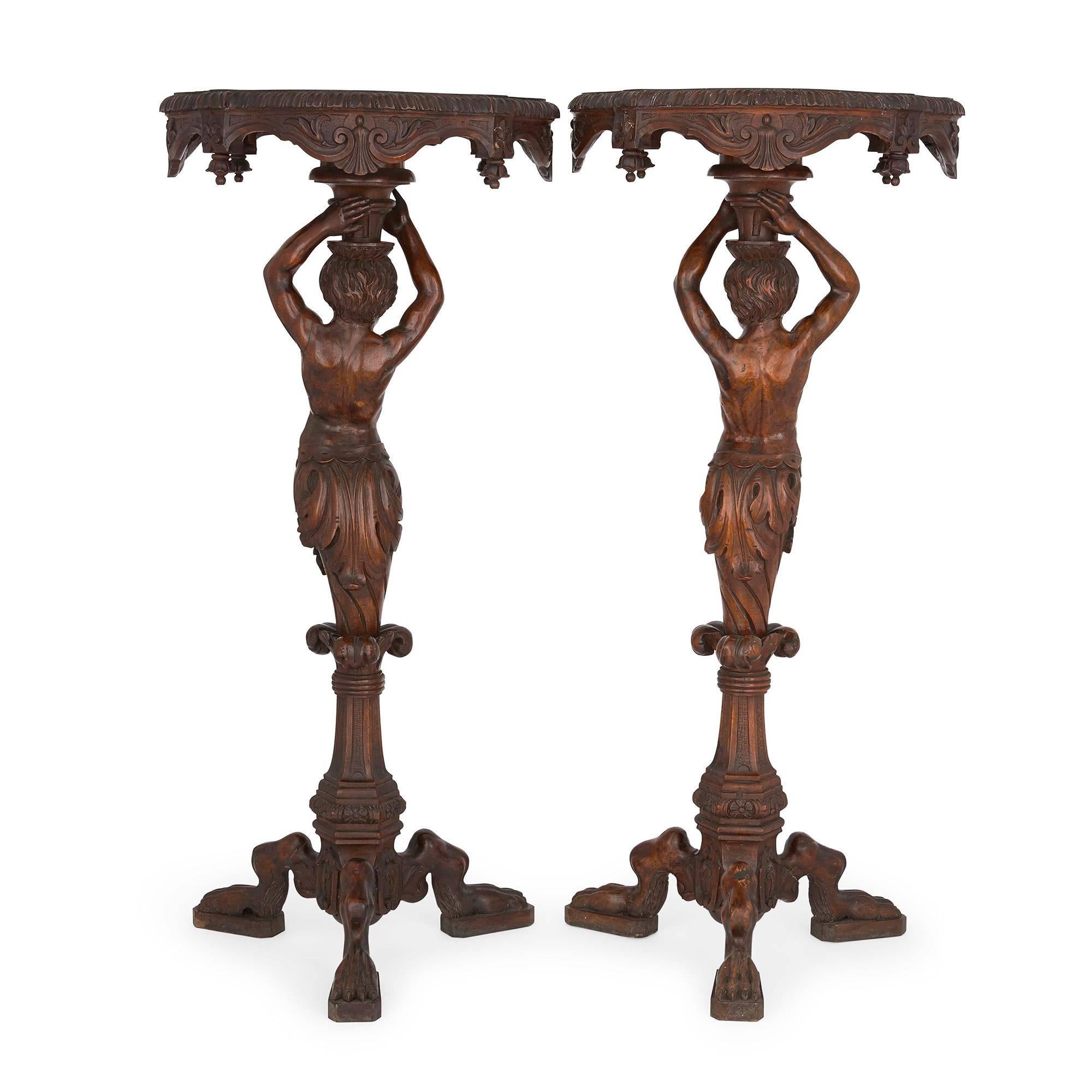 The tables circular surface with egg and dart rim, the tops above a carved nude male torso with hands raised, the male torsos each above a triform base with paw feet.


 