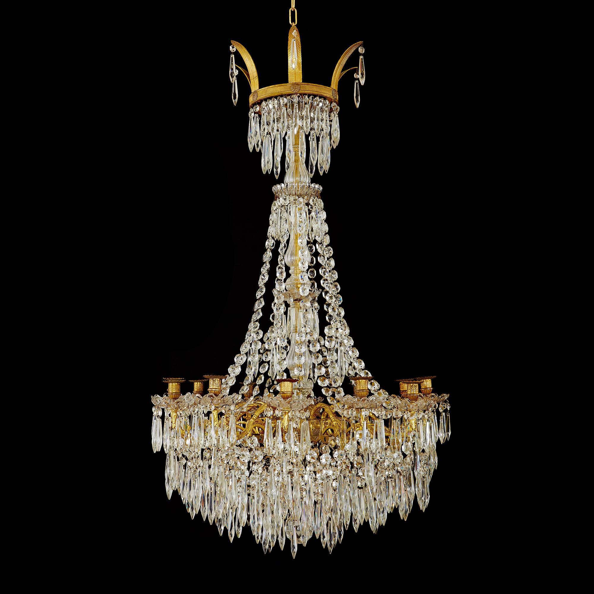 This exquisite chandelier is a true work of art, demonstrating the very finest of craftsmanship from the French Empire period. The chandelier is composed of a gilt bronze (ormolu) frame, which comprises a lower basket featuring scrolling branches of