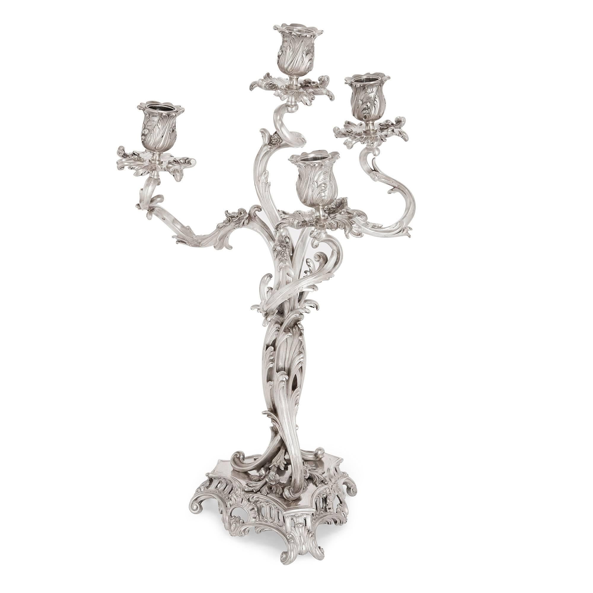 Both candelabras issuing four lights from scrolling branches, which lead to a central column and triangular base; the pair decorated asymmetrically throughout with leaves and flowers and marked 'Cardeilhac / Paris', with further hallmarks for Ernest