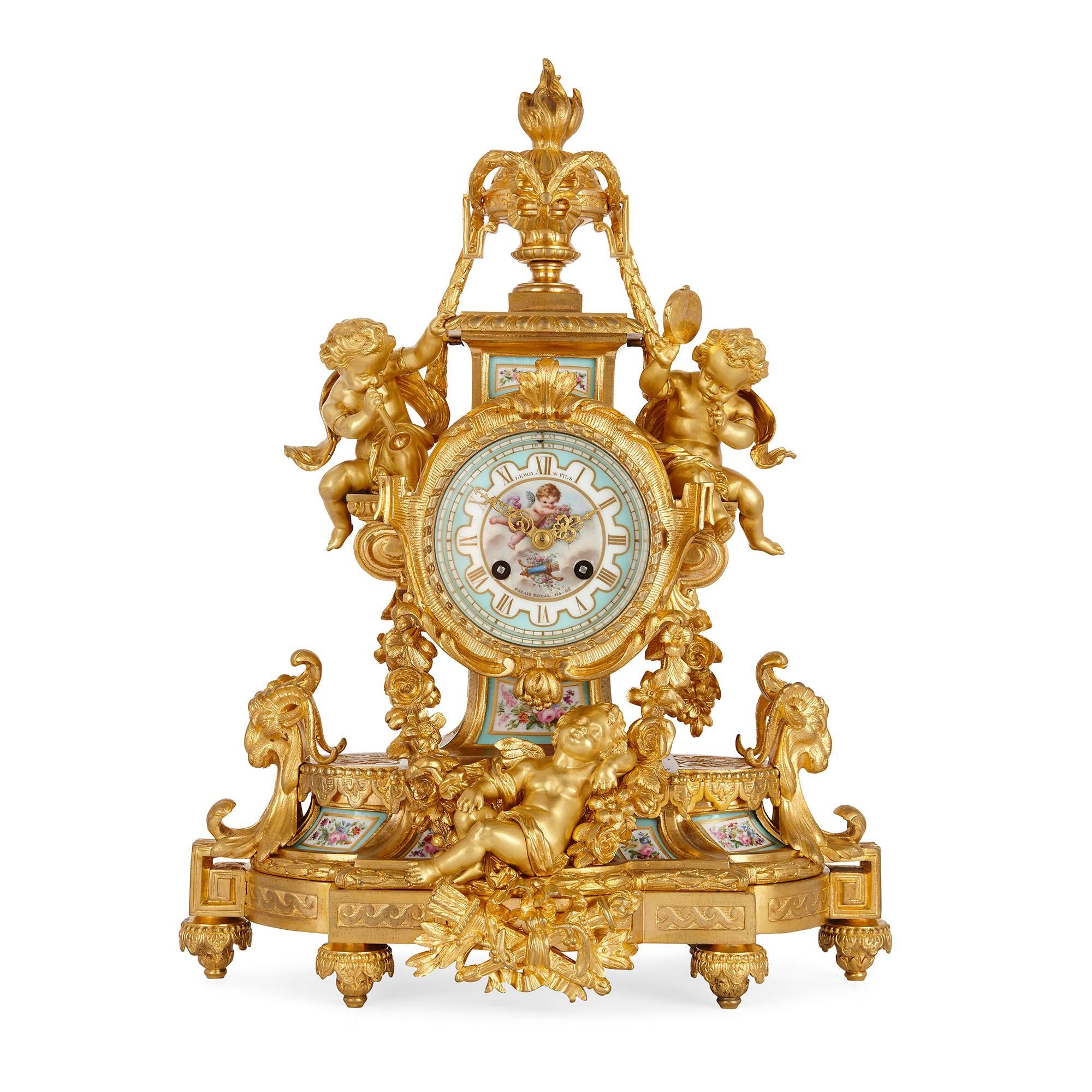 This exquisite antique French clock set is comprised of a central clock and a pair of flanking candelabra. The clock and accompanying candelabra are similarly decorated, with ormolu embellishments in the neoclassical style. The central clock itself