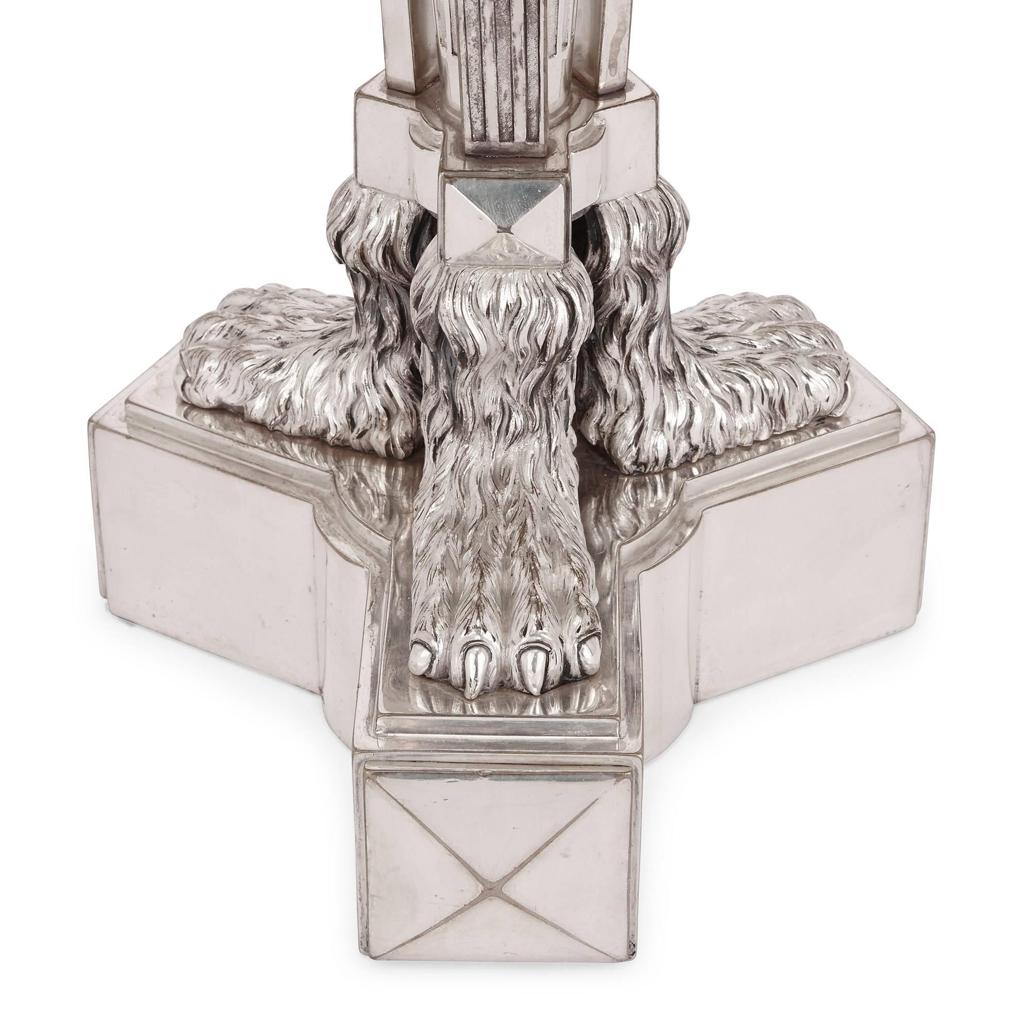 Questa coppia di antichi candelabri francesi placcati in argento in stile Regence sono sormontati da bruciatori di incenso, in cima ai quali si trovano finali fiammeggianti. La colonna centrale è scanalata e decorata con volute, che conducono