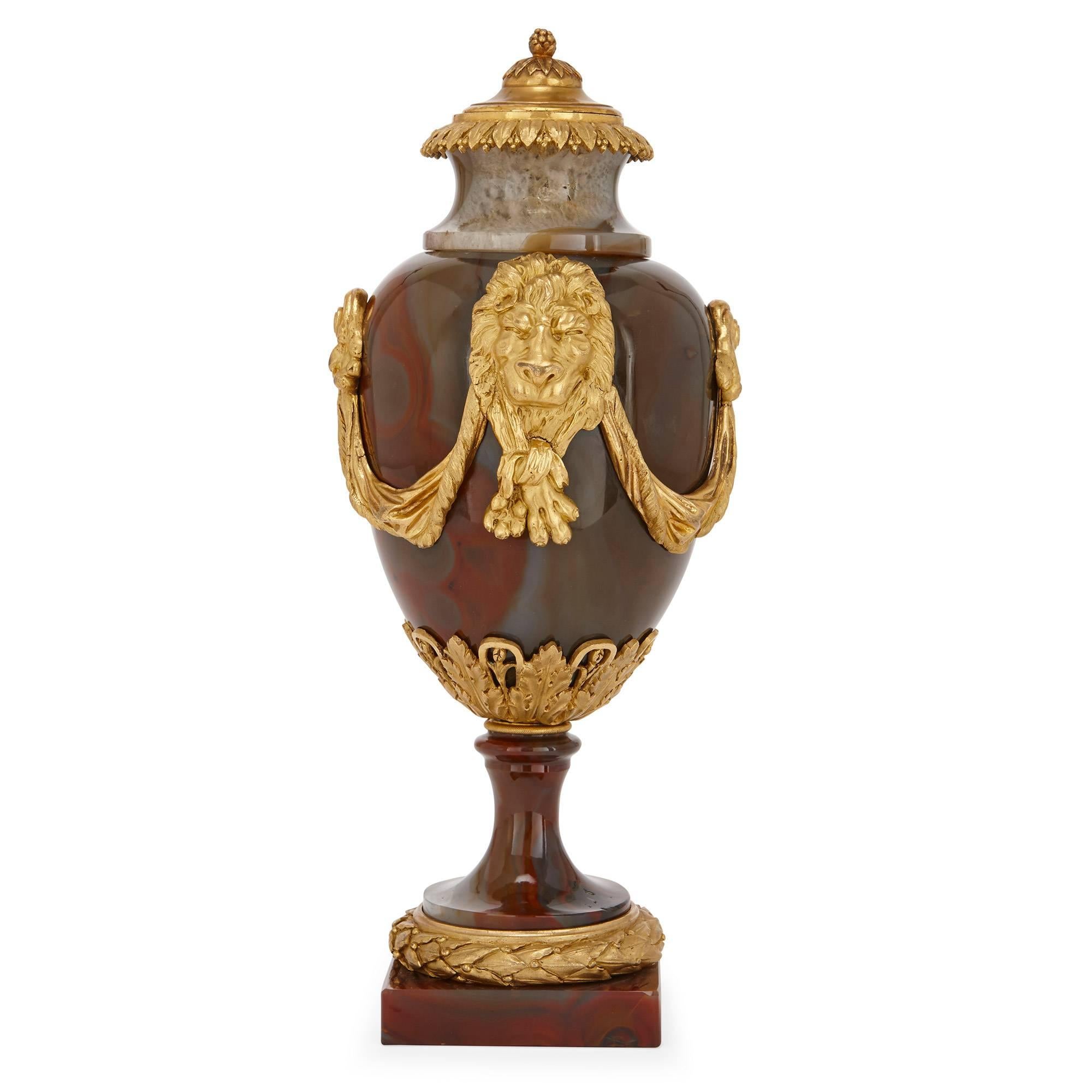 Estos excepcionales y raros jarrones antiguos de la época de Luis XVI están esculpidos en ágata, una piedra preciosa y muy codiciada. Los jarrones se asientan sobre bases cuadradas de ágata con zócalos de bronce dorado con una corona de laurel. Los