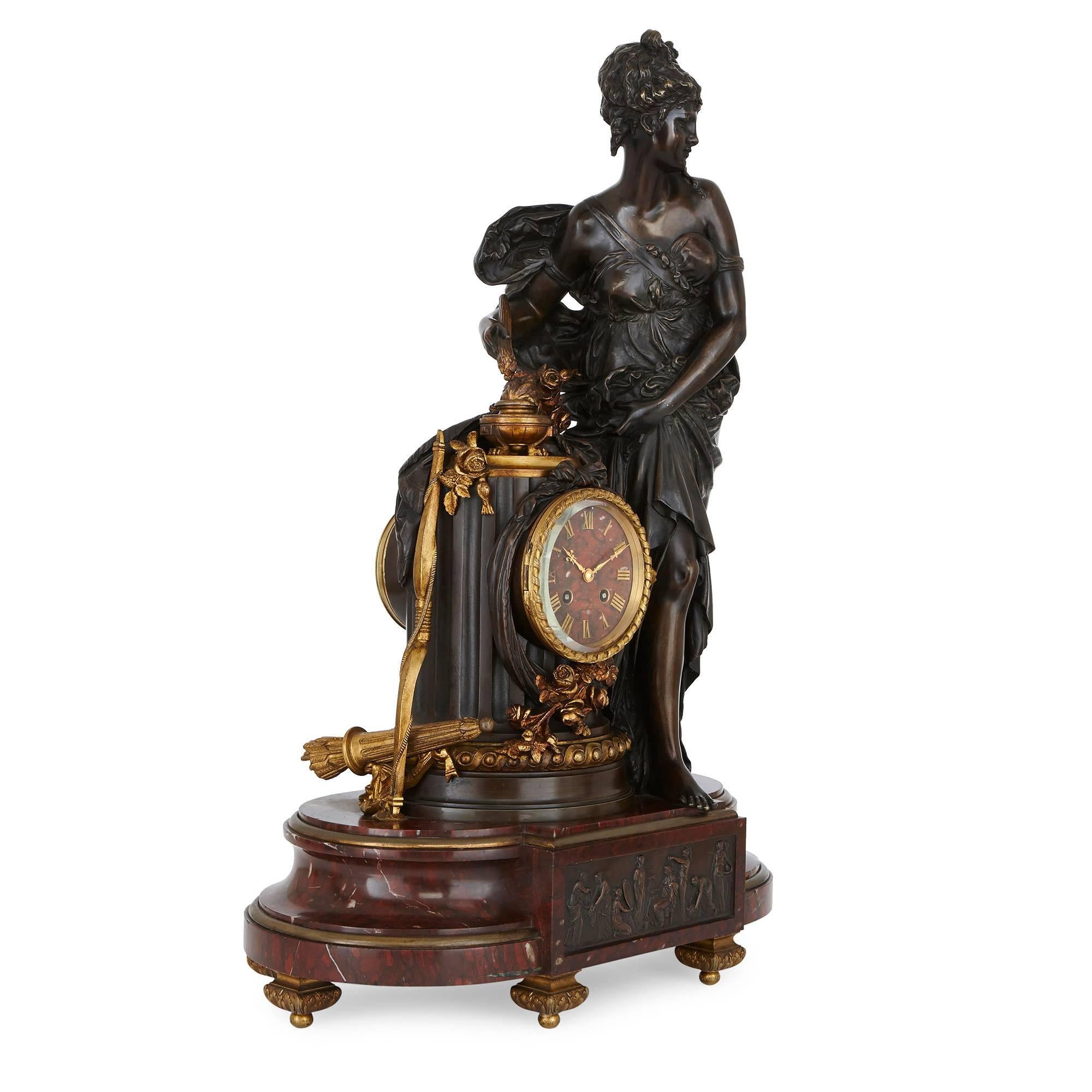 This fine and ornate antique clock set by Lemerle-Charpentier & Compagnie comprises a clock and two flanking candelabra. The asymmetrical clock is set on a red marble base with ormolu feet and features a central relief panel in patinated bronze. The