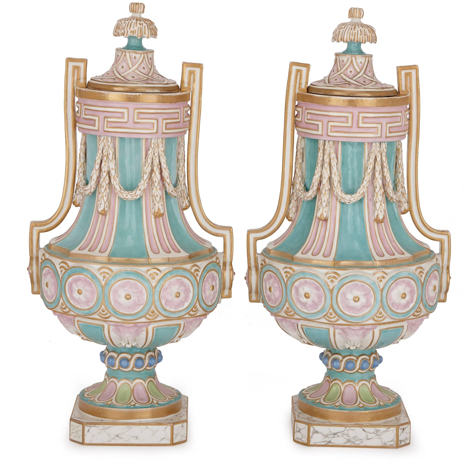 This pair of antique German porcelain vases are designed with Neoclassical features and elegantly decorated in pastel colors. Each vase is surmounted with a lid and features twin handles at the sides, which are joined by white porcelain garlands