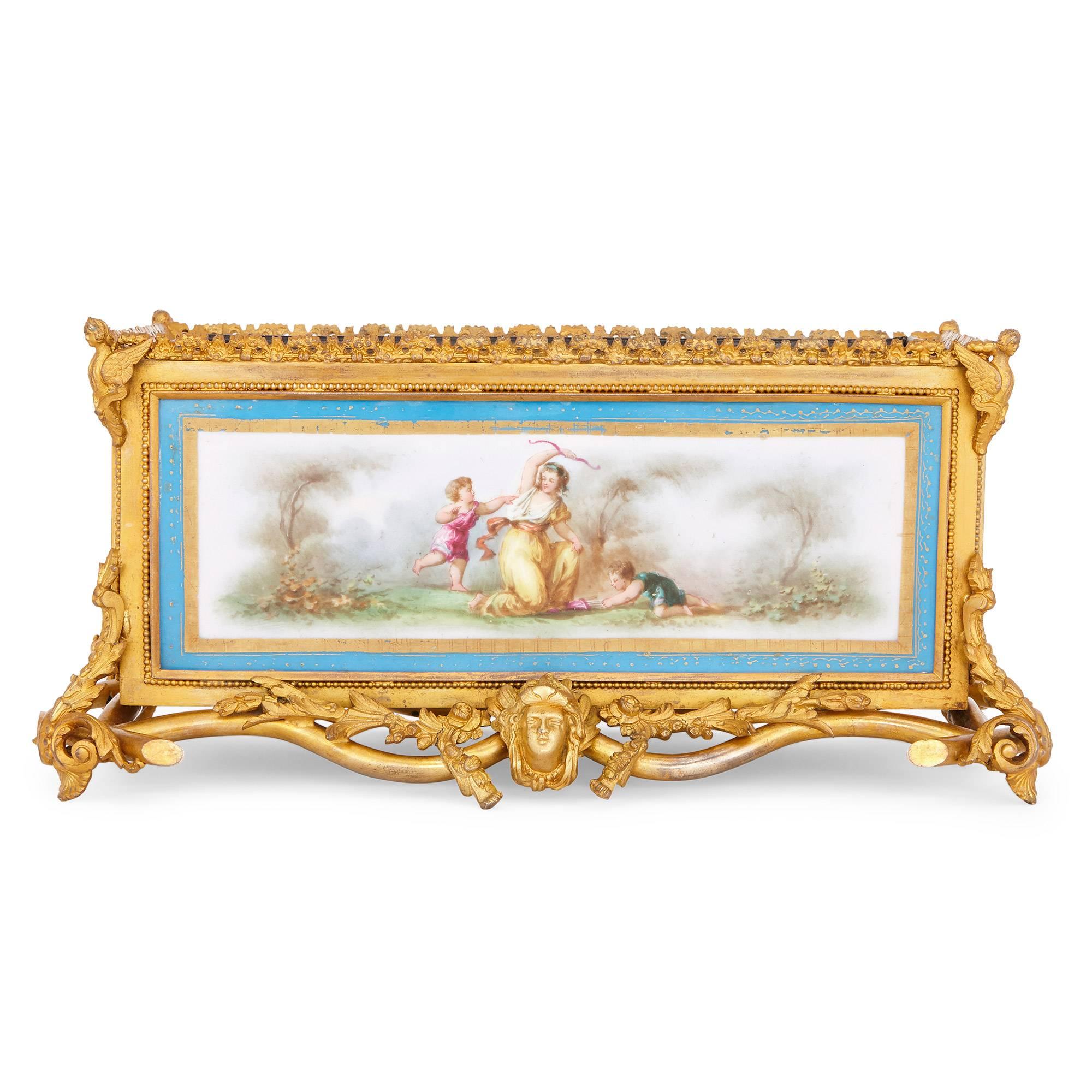 This beautiful French antique jardiniere features intricate gilt bronze mounts and four Sevres style porcelain plaques. The base of the jardiniere is particularly ornate: crafted from cast and punctured gilt bronze, it takes the form of scrolling