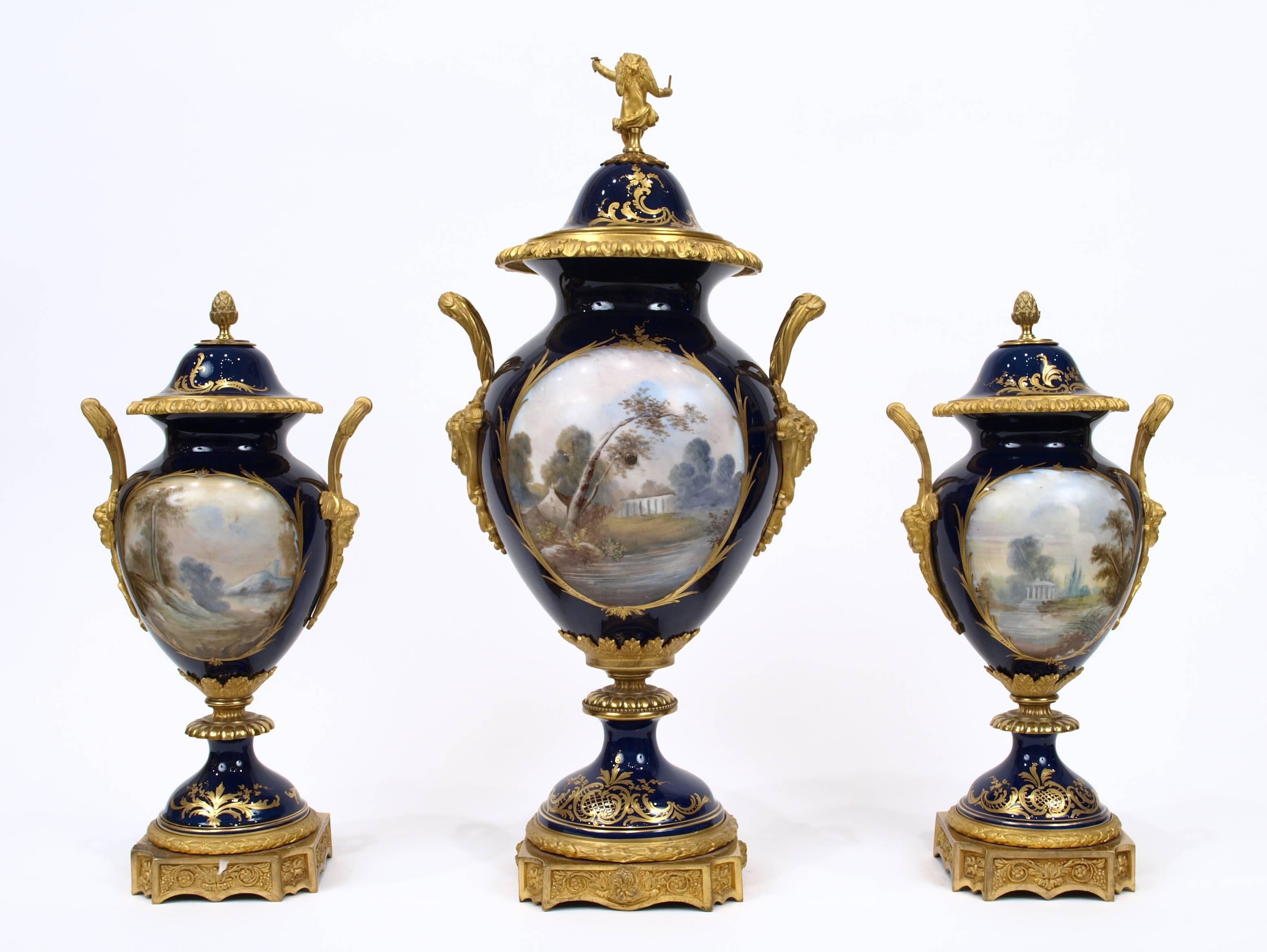 This fantastic porcelain clock garniture contains three vases, one of which has been mounted with a ormolu clock dial with jewels surrounding it. The vases are decorated in the style of the Sèvres Porcelain manufacturers, with cartouches to the