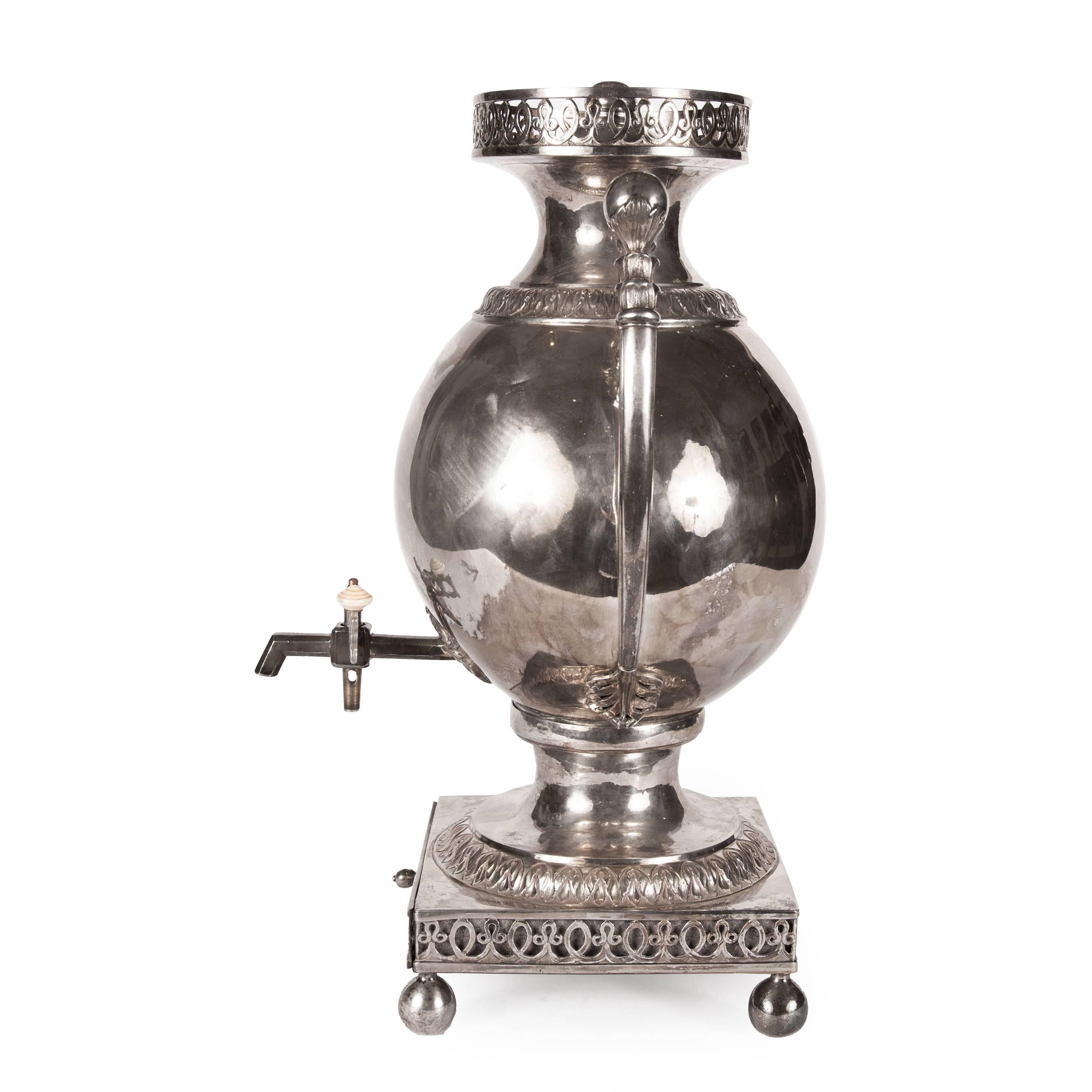 This stunning Russian samovar was cast in solid silver in the 18th Century. The samovar stands on a square base with scrolling motifs and four ball feet. The body of the samovar is ovoid and features a dispensing tap to the lower section and twin