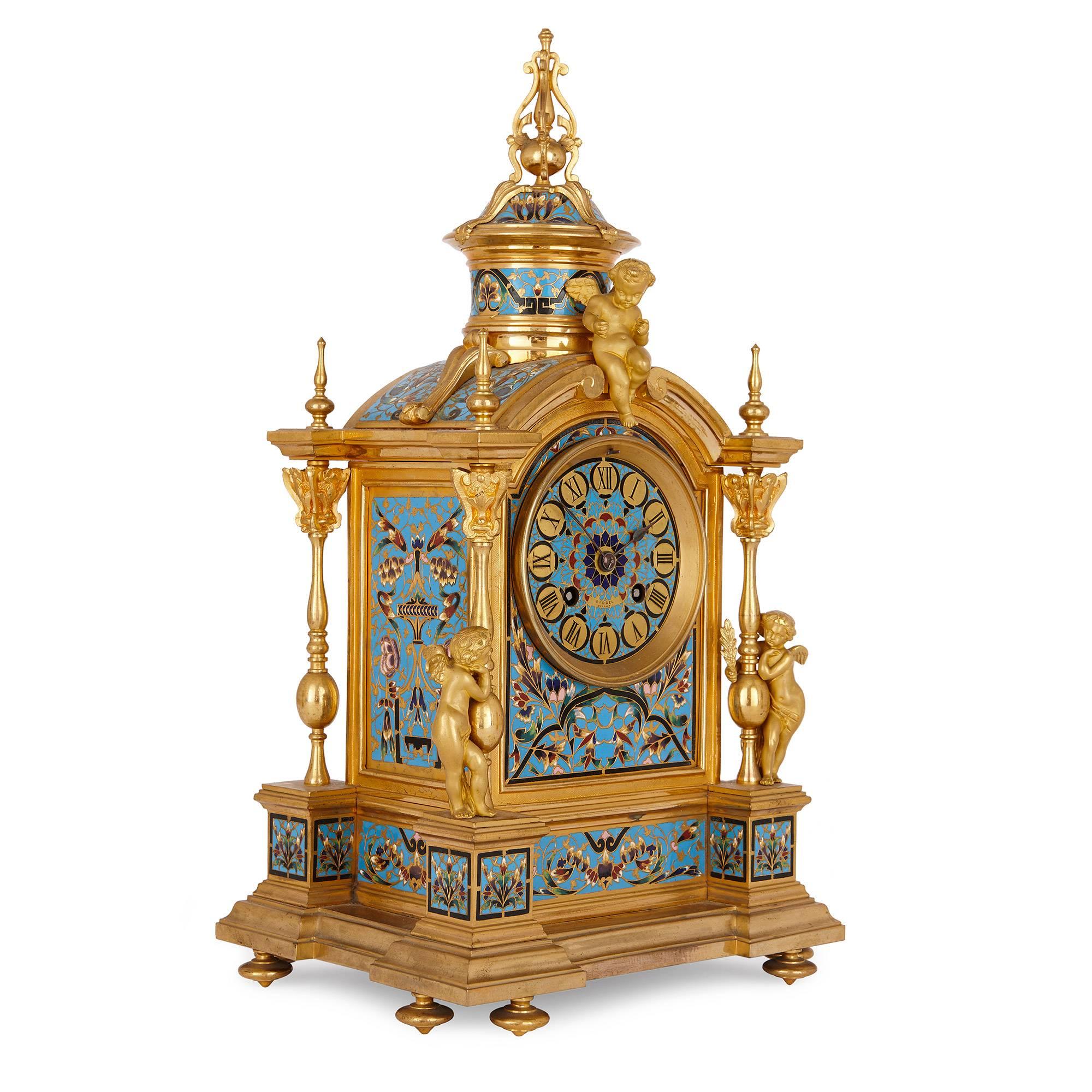 Dieses außergewöhnlich detailreiche Uhrenset besteht aus einer Kaminsimsuhr und zwei dazugehörigen Vasen, die alle aus Ormolu gefertigt und aufwändig mit leuchtendem Cloisonné-Email verziert sind. Die Uhr steht auf Ormolu-Toupie-Füßen, auf denen der