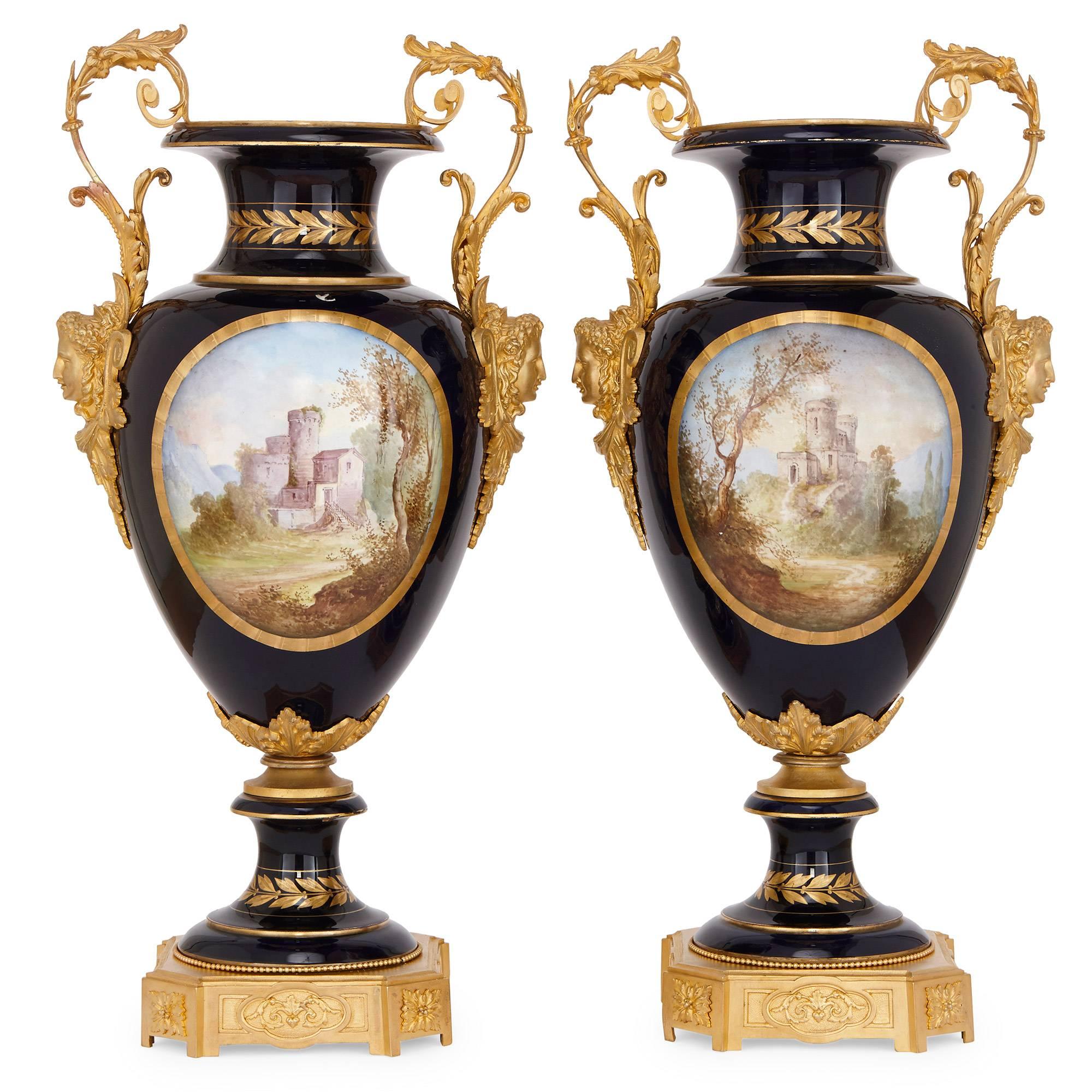 The pair of vases are each crafted in baluster form porcelain with a deep, ink blue ground, and feature waisted socle bases and waisted necks with flared rims. The base of each porcelain vase is set onto an ormolu plinth of square form with canted