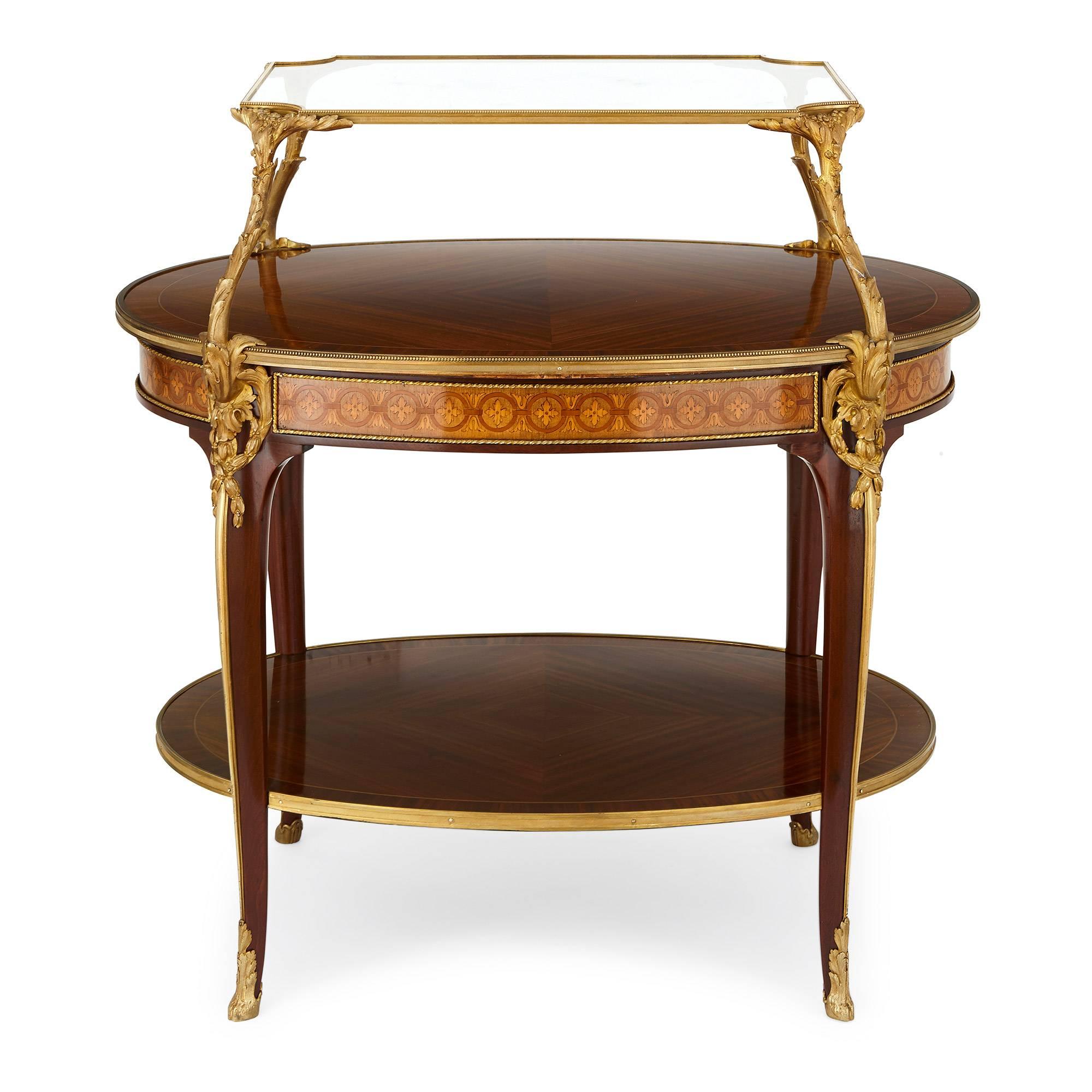 This fine satinwood tea table is made by the highly celebrated Parisian cabinetmaker Francois Linke (French, 1855-1946). The table features a glass tray of rectangular shape which sits upon ormolu supports in acathus leaf form, which themselves are