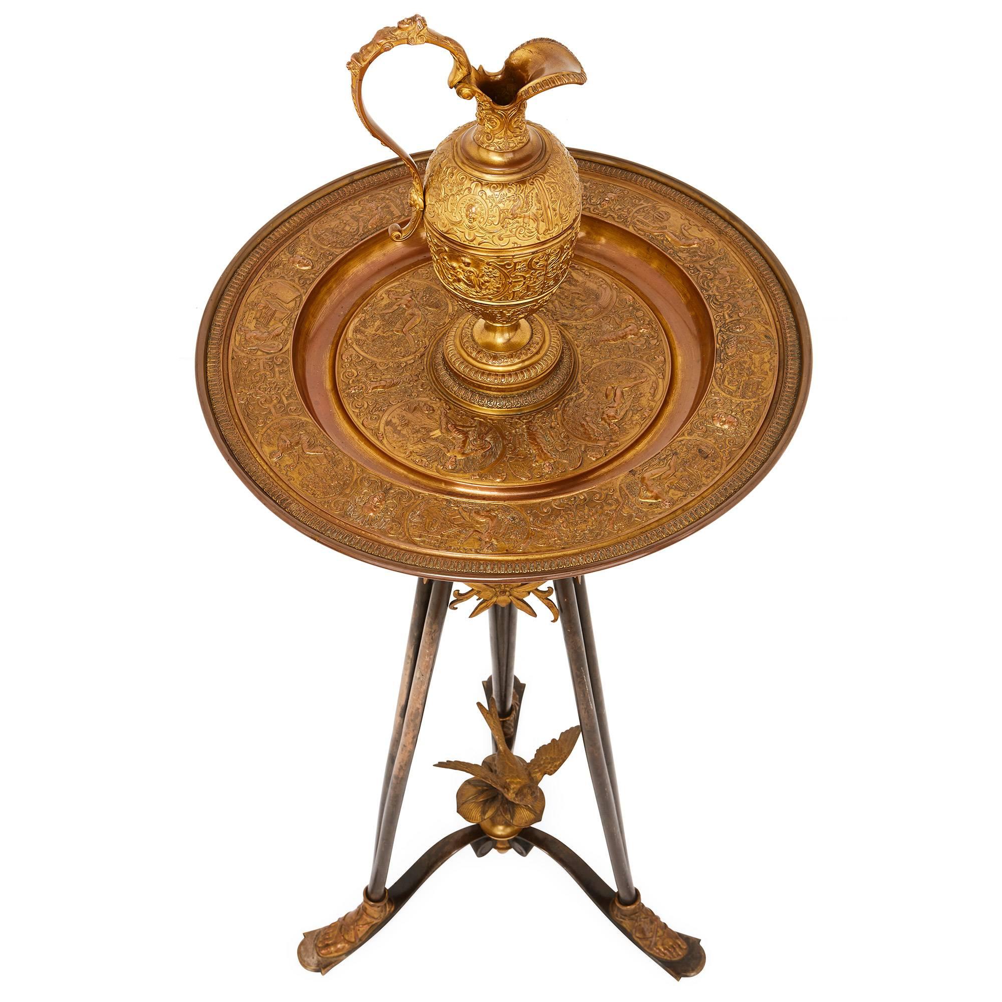 The exceptional bronze casting, in stunningly intricate detail, on this beautiful sculptural piece has been attributed to master metalworker Ferdinand Barbedienne. The piece takes the form of a bronze ewer on a large round basin platter and a tripod
