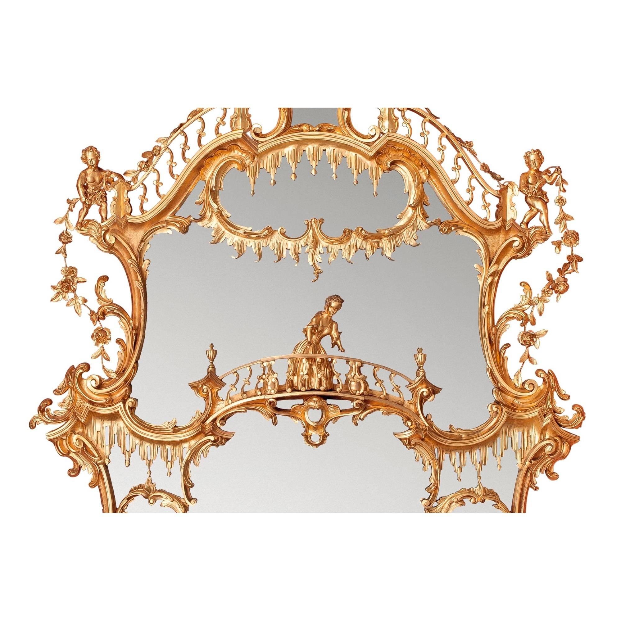 This exceptional over-mantle mirror has a prestigious provenance, having been in the collection of a renowned English aristocratic family. The work is surmounted by a spread eagle bearing rose flower swags in its beak above an arched galleried