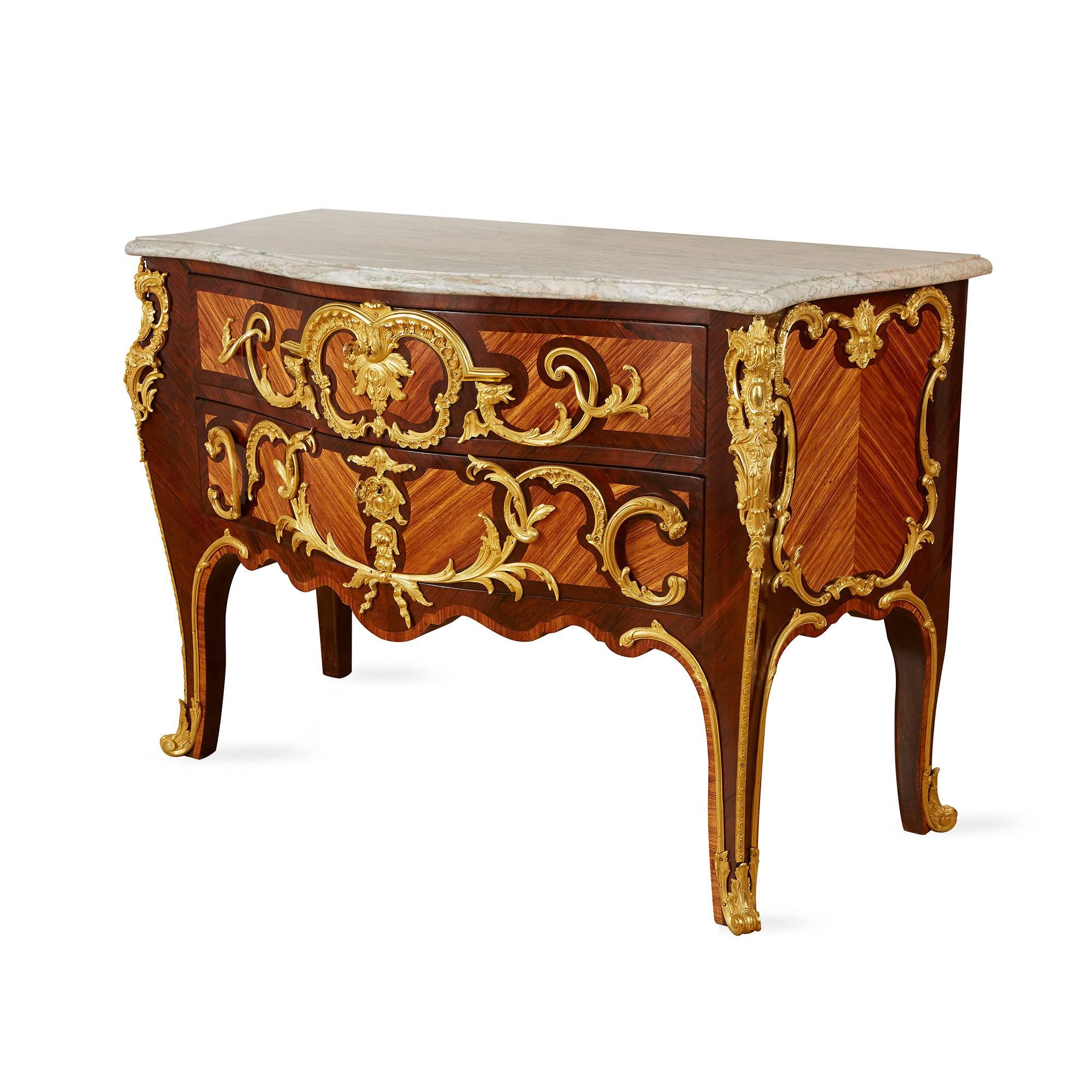 The parquetry inlaid with cartouches and a decorative frieze, the convex front with two transversal drawers with ormolu mounts and scrolled sabots.

After models by Charles Cressent (French, 1685-1768).  Cressent was a very highly regarded French