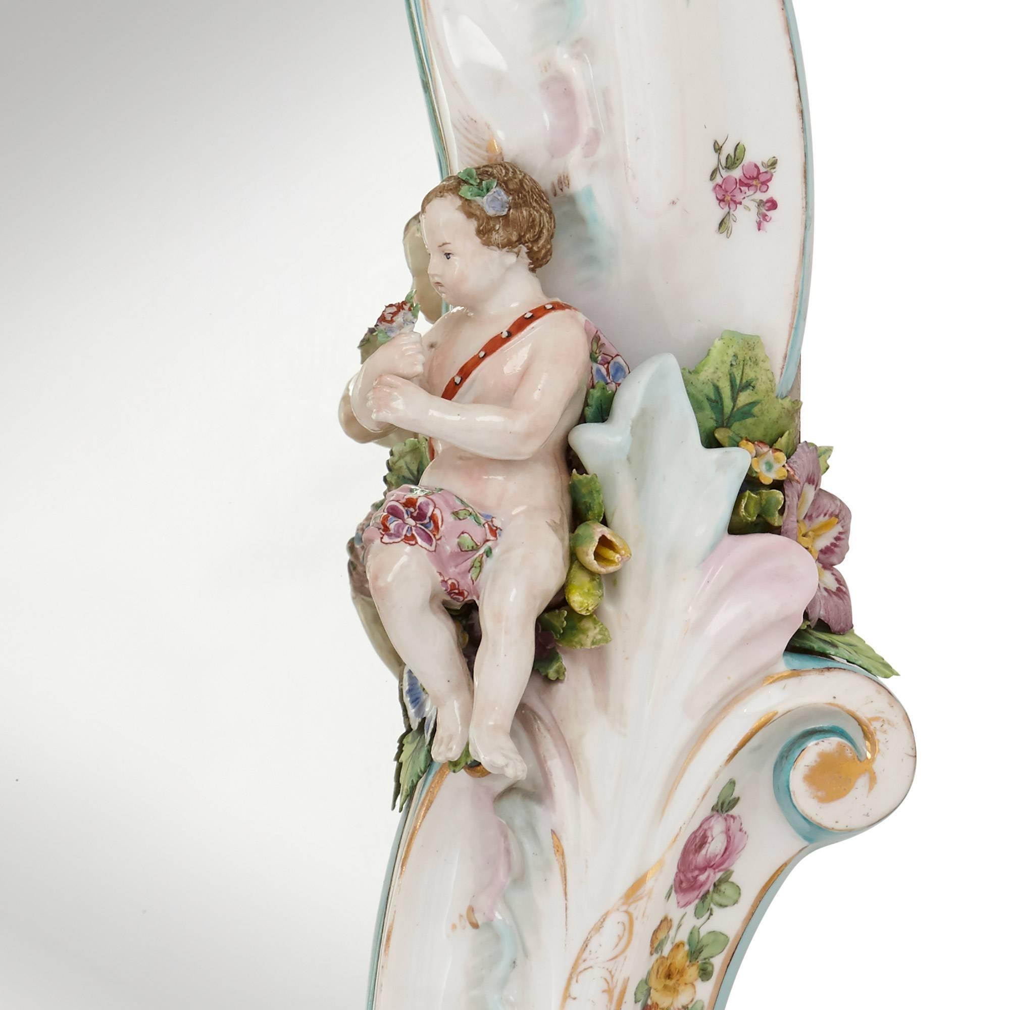 This antique mirror is decorated in the German Rococo style with beautiful painted flowers and scrolling foliage, and is mounted with porcelain figures of children. The mirror was manufactured in Dresden, Germany and dates from the late 19th century