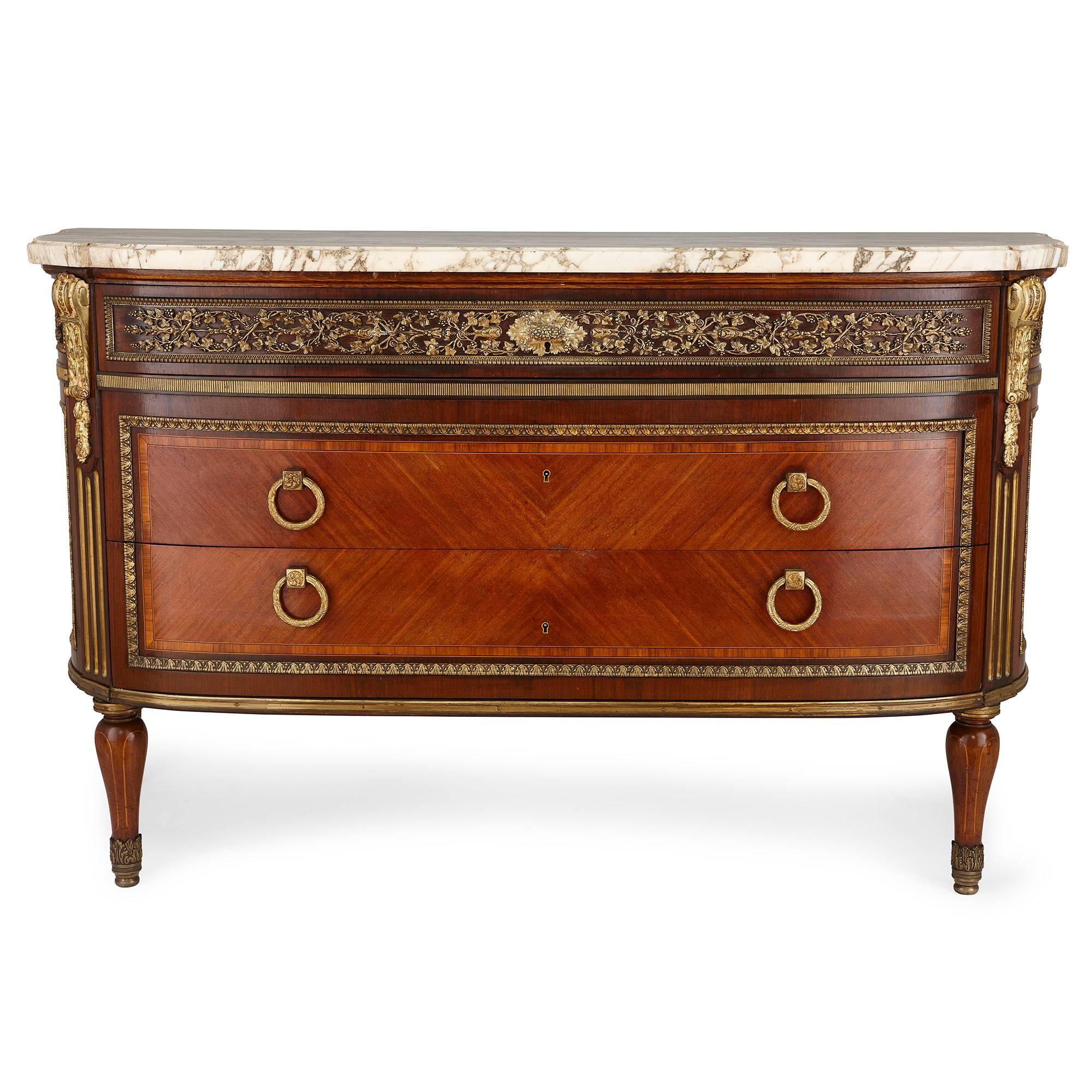 This fine, delicately ornamented commode was built by French designers Myrtil Dennery and Paul Alexandre who were active in the early 20th century, after the 18th Century model by celebrated French cabinetmaker Jean-Francois Leleu (French,