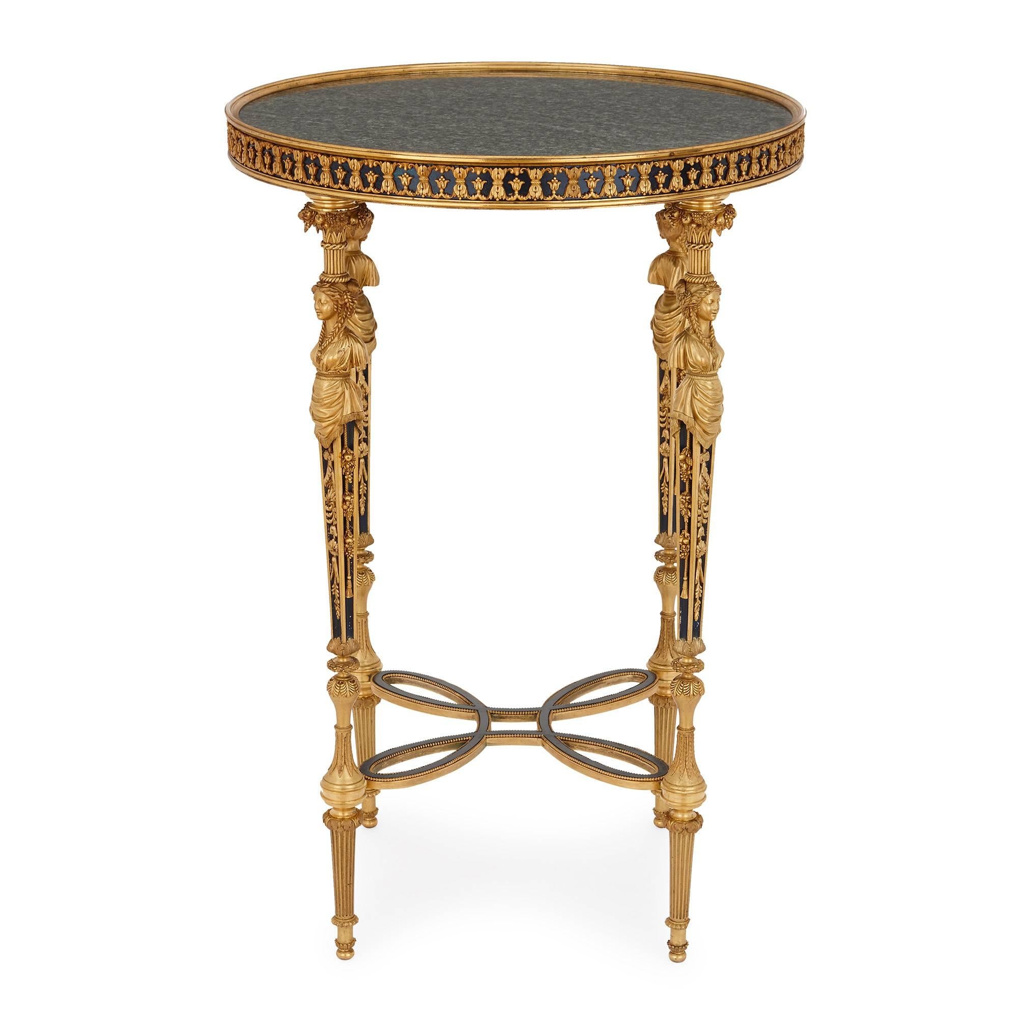 This refined and elegant round side table, or gueridon, has a circular top of green veined marble. Running around the edge of the top of the table is a band of tole, which is mounted with ormolu in a repeating floral pattern. The table top is set on