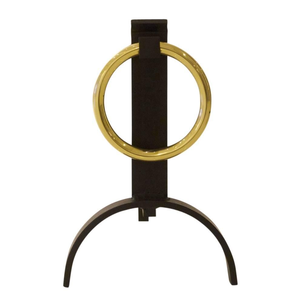 Donald Deskey style andirons brass buckle, USA, 1960s. Circular brass buckle motif andirons with arched base and wrought iron shanks. The brass buckle was re-finished and the iron elements were restored in matte black and then waxed.