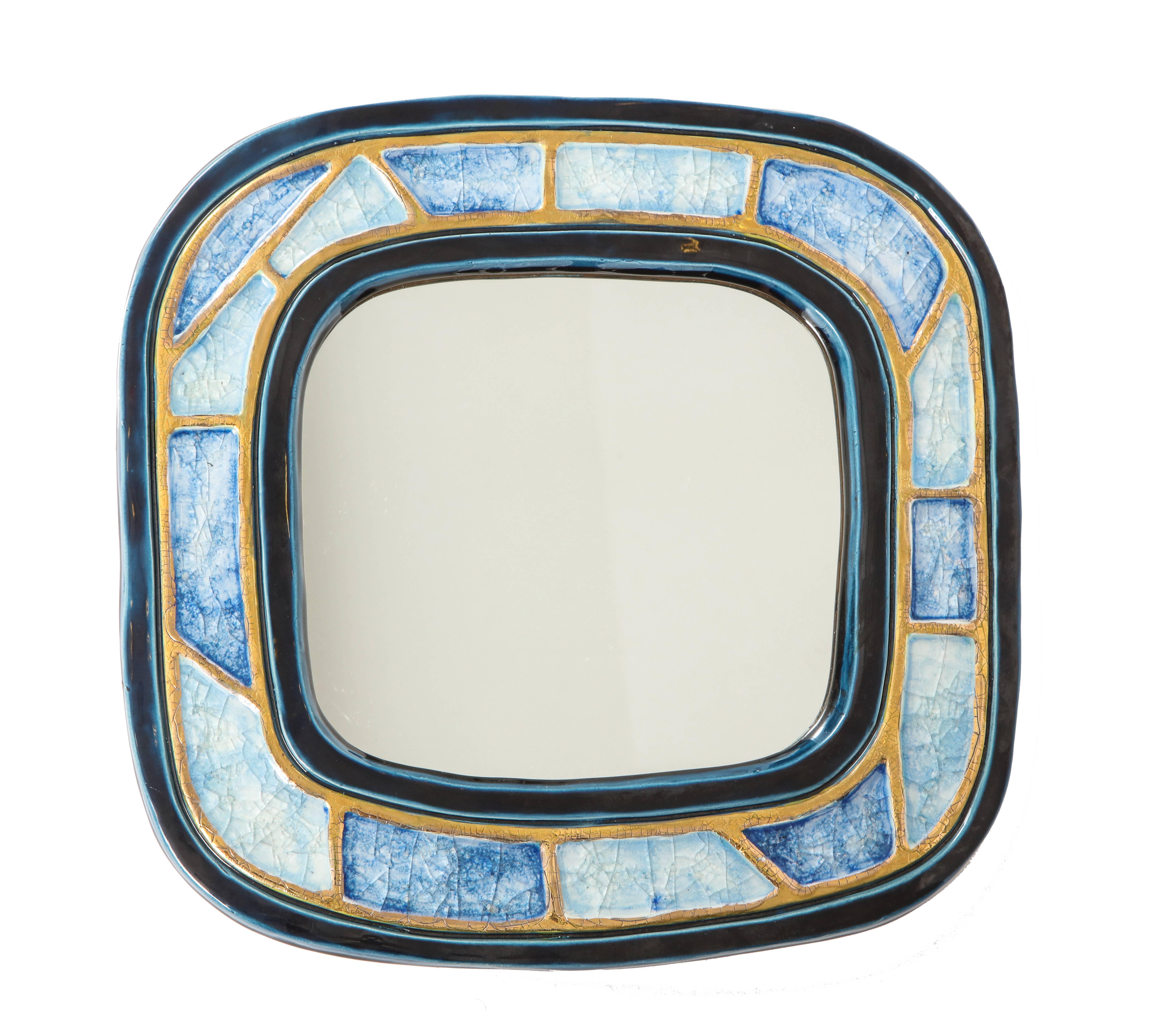Mithé Espelt mirror, ceramic, gold and blue, fused glass. Small scale rounded square mirror decorated with two tones of blue fused glass framed by a crackle gold glaze. Felt covered back.
