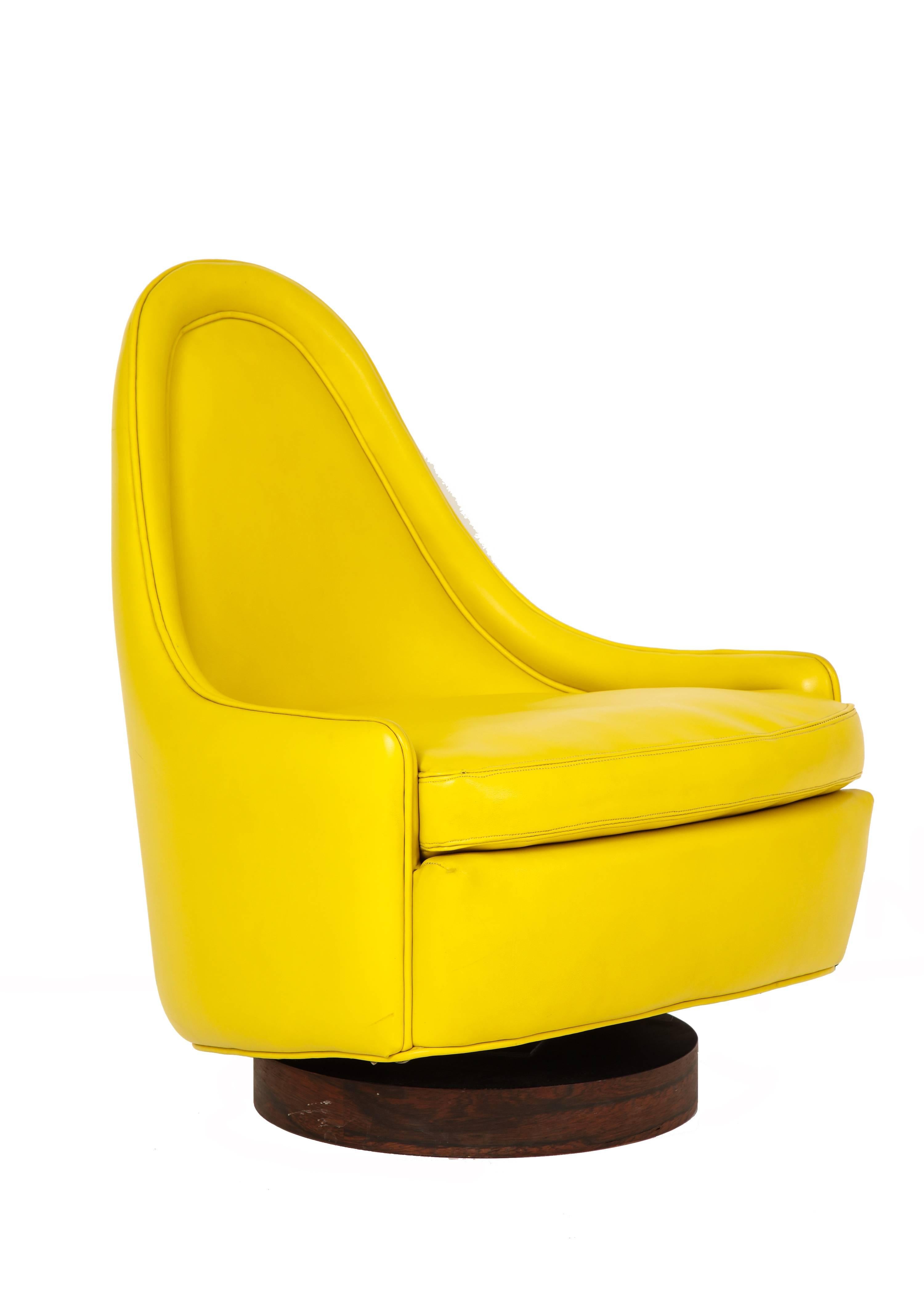 Milo Baughman Swiveling Lounge Chair, Yellow, Rosewood, Signed. Teardrop form petite slipper lounge chair that tilts and swivels on a rosewood veneer circular base and upholstered in the original 1970s bright canary yellow vinyl. Retains two Thayer
