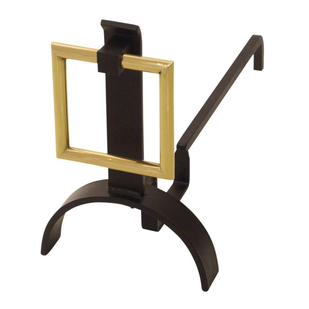 Donald Deskey style andirons brass buckle, USA, 1960s. Square brass buckle motif andirons with half circle base and wrought iron shanks. The brass buckle was re-finished and the iron elements were restored in matte black and then waxed. 

