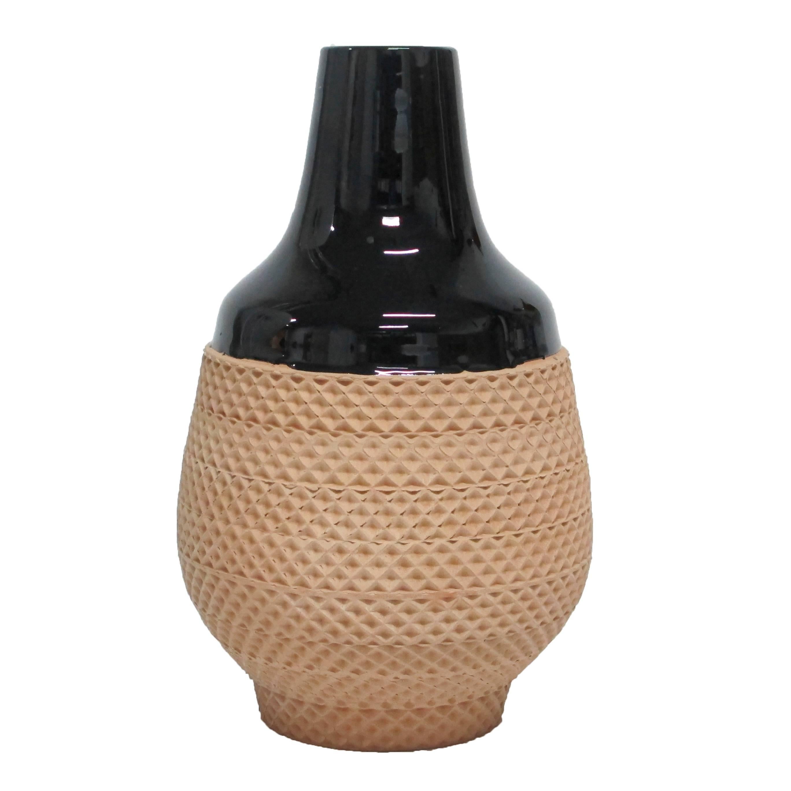 Bitossi ceramic vase black glaze impressed terracotta signed, Italy, 1970s. The neck and shoulders of the vase have a glossy black glaze contrasted by a unglazed terracotta waist, belly and foot. Measures 10 inches in height by 6 inches across the