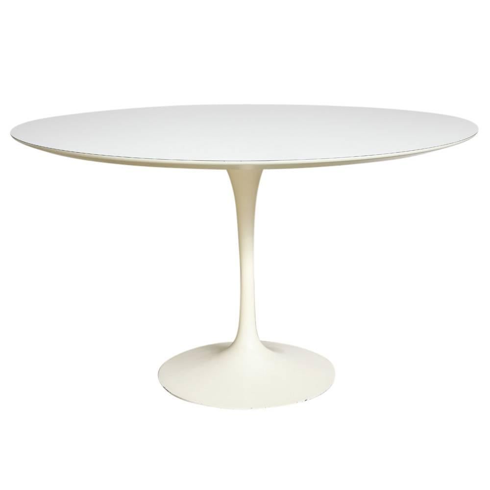 Knoll Saarinen round dining table white laminate cast iron 48 inches. Early production white laminate pedestal dining table by Eero Saarinen for Knoll in good original condition with beveled edge and powder coated cast iron base. Base has a sunken