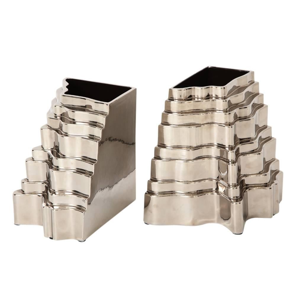 Sergio Asti Collina vases, ceramic, metallic silver chrome, signed. Two Collina (Hill in Italian) Series vases glazed metallic silver chrome. The vessels' design emulates a hill or grade with multiple graduated steps. Both vessels are signed with a