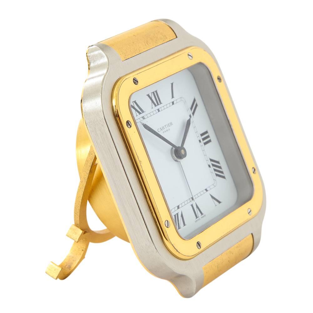 Cartier clock quartz Santos gold-plated brushed steel signed, France, 1980s. Handsome men's gold-plated stainless steel two-tone Cartier Santos alarm clock with Swiss made quartz movement. White dial with black Roman numerals and sword hands. Marked