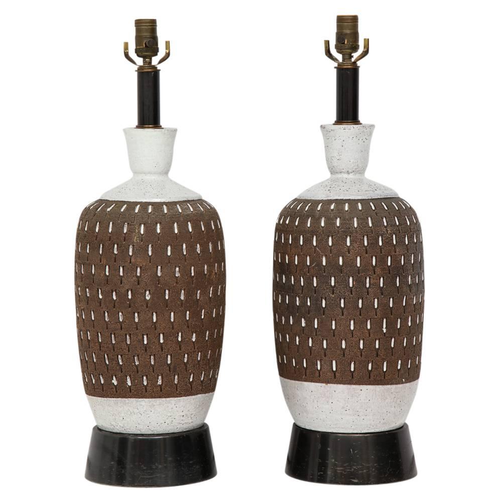 Bitossi ceramic table lamps pair incised brown white signed, Italy, 1960s. Ceramic bodies are in excellent condition. Both retains their original sockets and wiring. Both are mounted on black lacquered wood bases. Wear to the paint on bases.
Ceramic