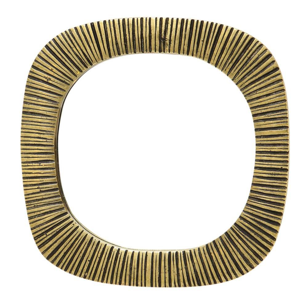 Specchio in bronzo, con nervature. Uno specchio in scala ridotta che abbiamo acquistato a Parigi. Fusione in bronzo di qualità con decorazione a coste incise. Il verso è rivestito in pelle.
