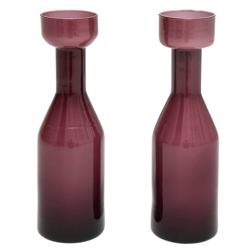 AV Mazzega vases, case glass, purple amethyst. Pair of medium scale bottle form case glass vases. Minor discoloration and bubbling to the lip of one of the vases.
 