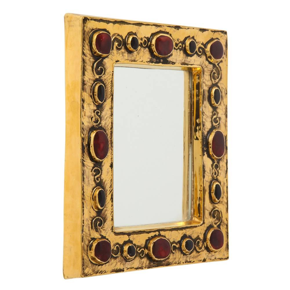 Francois Lembo mirror, ceramic, gold and red, jeweled, signed. Small scale gold glazed mirror decorated with ruby red embedded jewels. Signed F. Lembo with incised signature on the back. 

A native of Vallauris François Lembo started his pottery