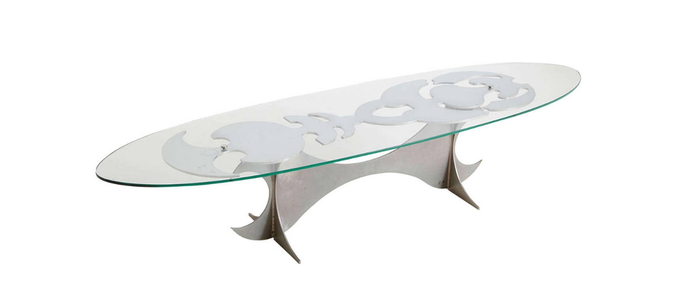 Coffee table by Armand Jonckers (Born in 1939), 
1970s, Belgium.
Double pedestal base.
Elongated abstract tattoo like pattern.
Polished chromed steel.
Oval shaped thick glass top.
in good condition.
  